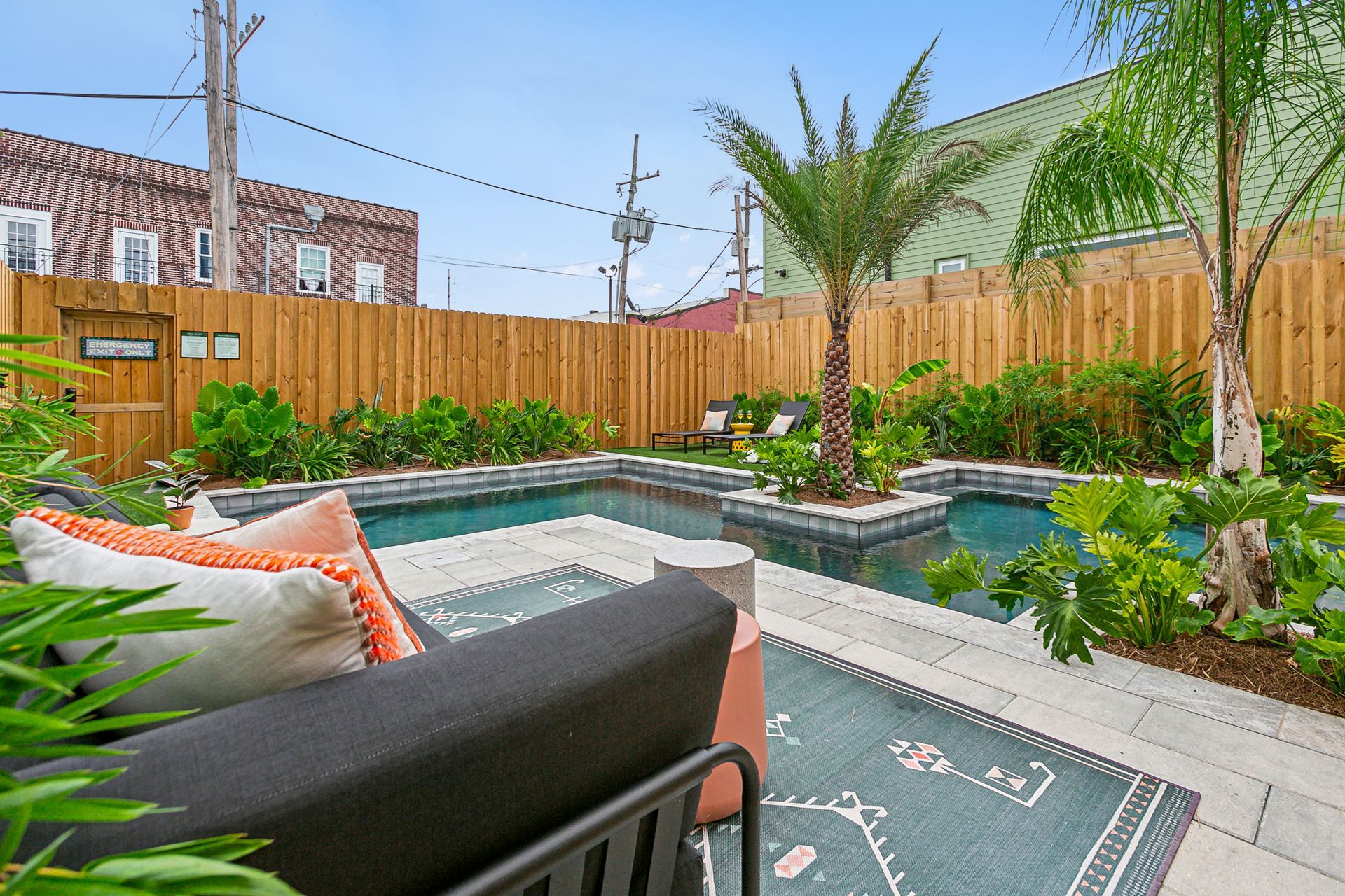 A backyard with a swimming pool and a wooden fence.