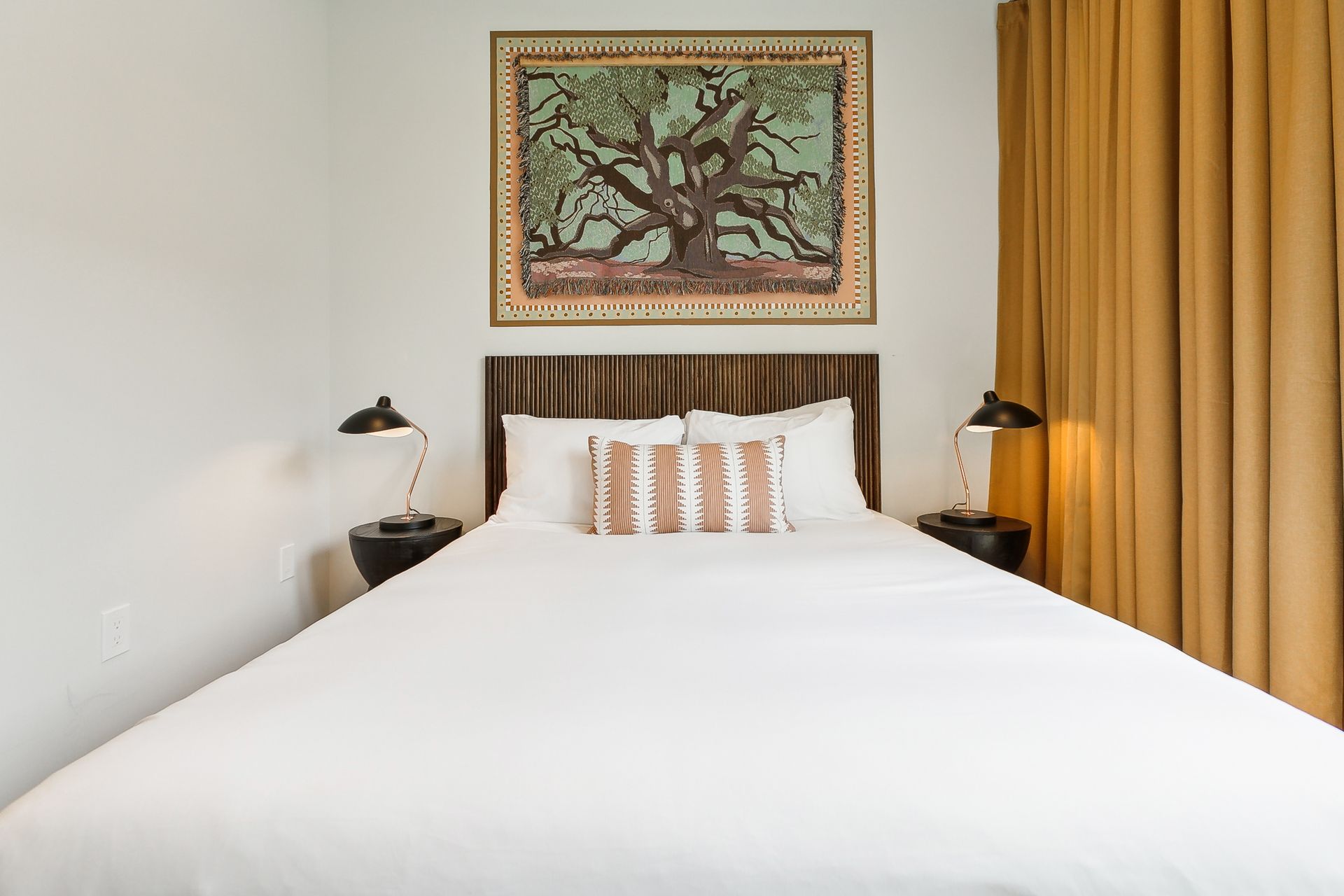 There is a painting on the wall above the bed.