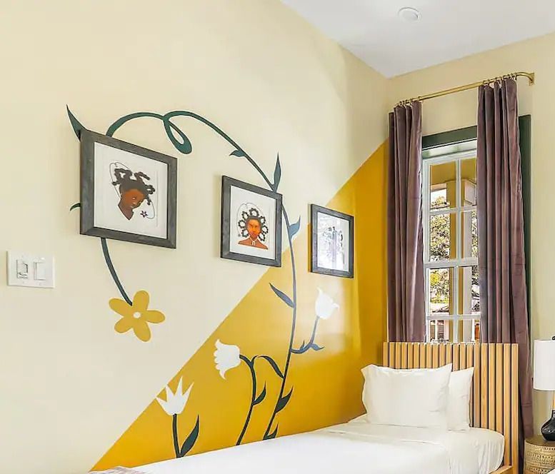 A bedroom with yellow and white walls and a bed