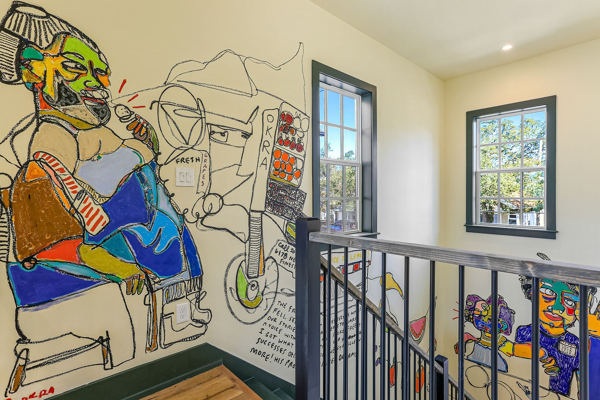 A staircase with a painting on the wall and a window.