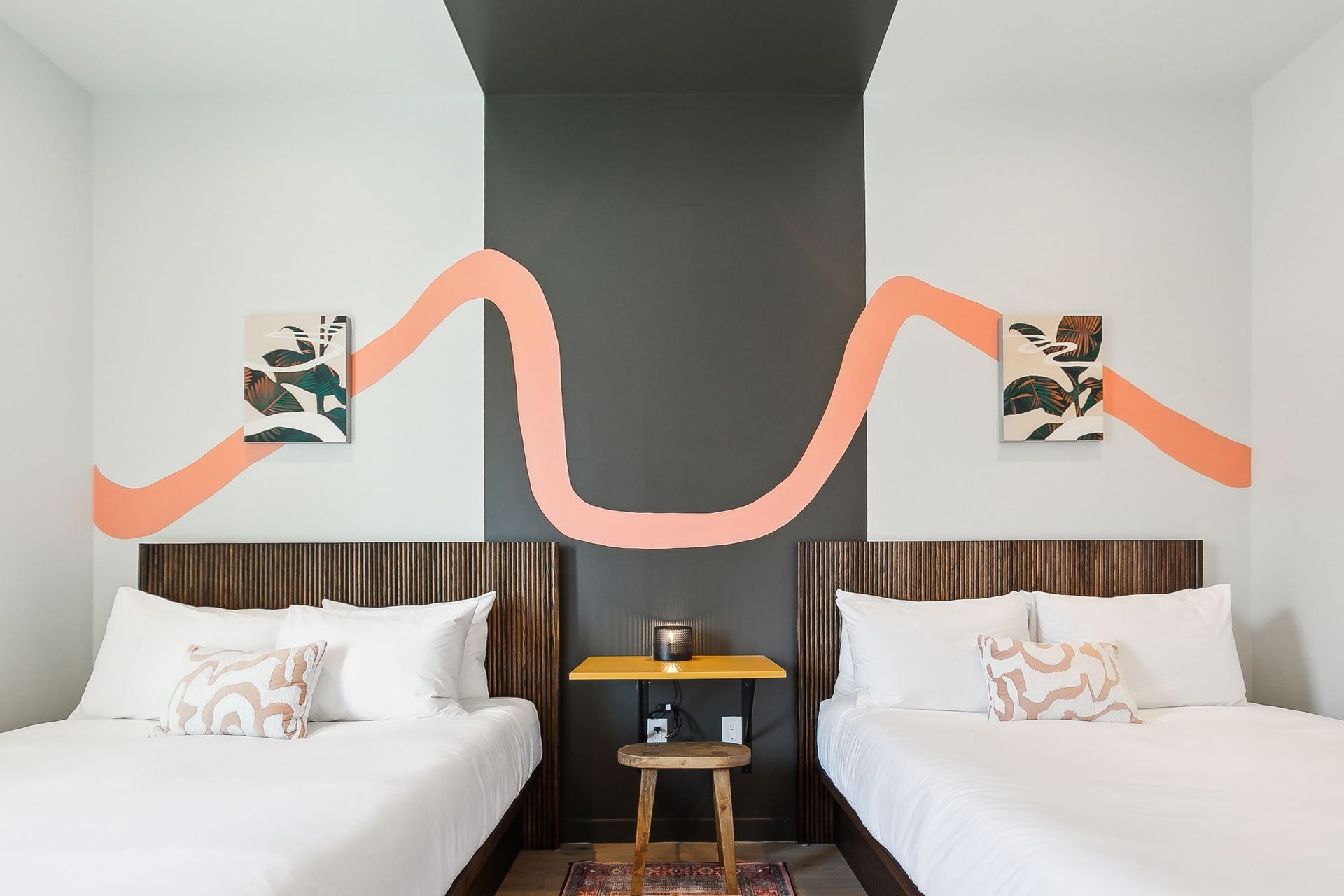 A hotel room with two beds and a table.