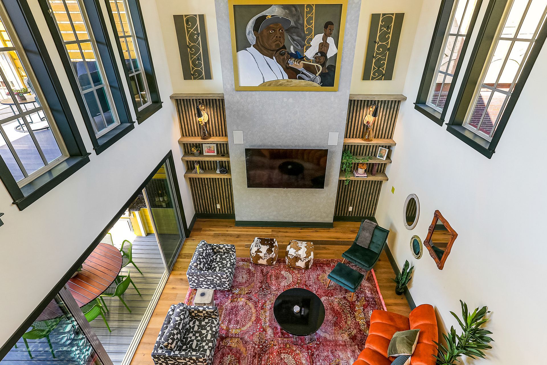 An aerial view of a living room with a fireplace and a painting on the wall.