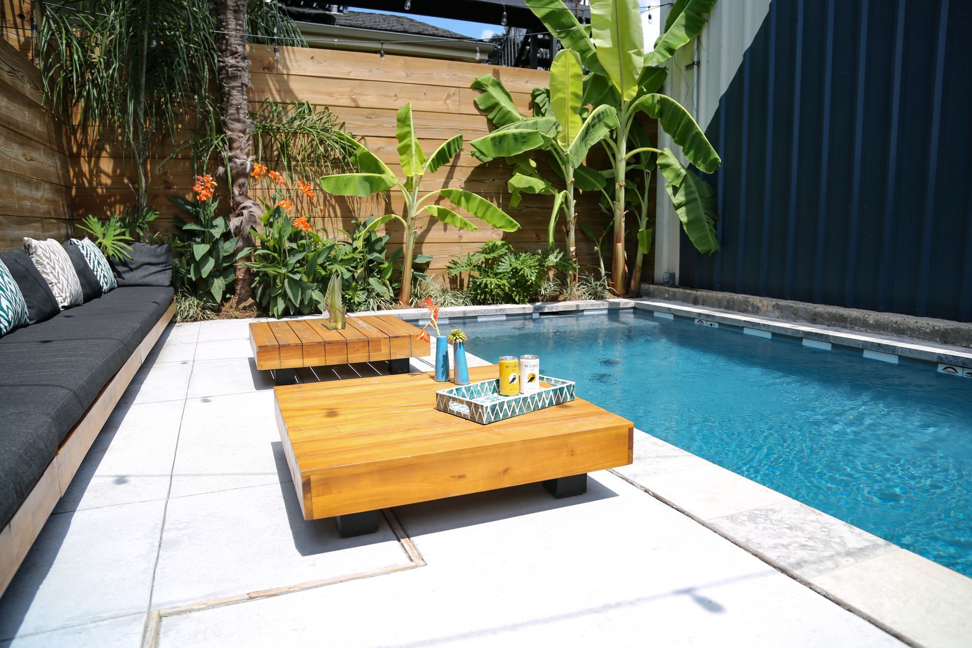 A wooden table is sitting next to a swimming pool.