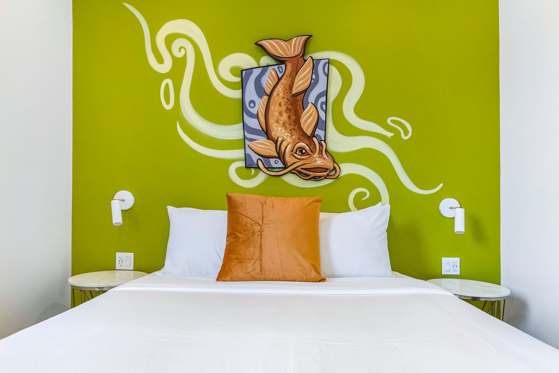 A bed with a painting of an octopus on the wall above it