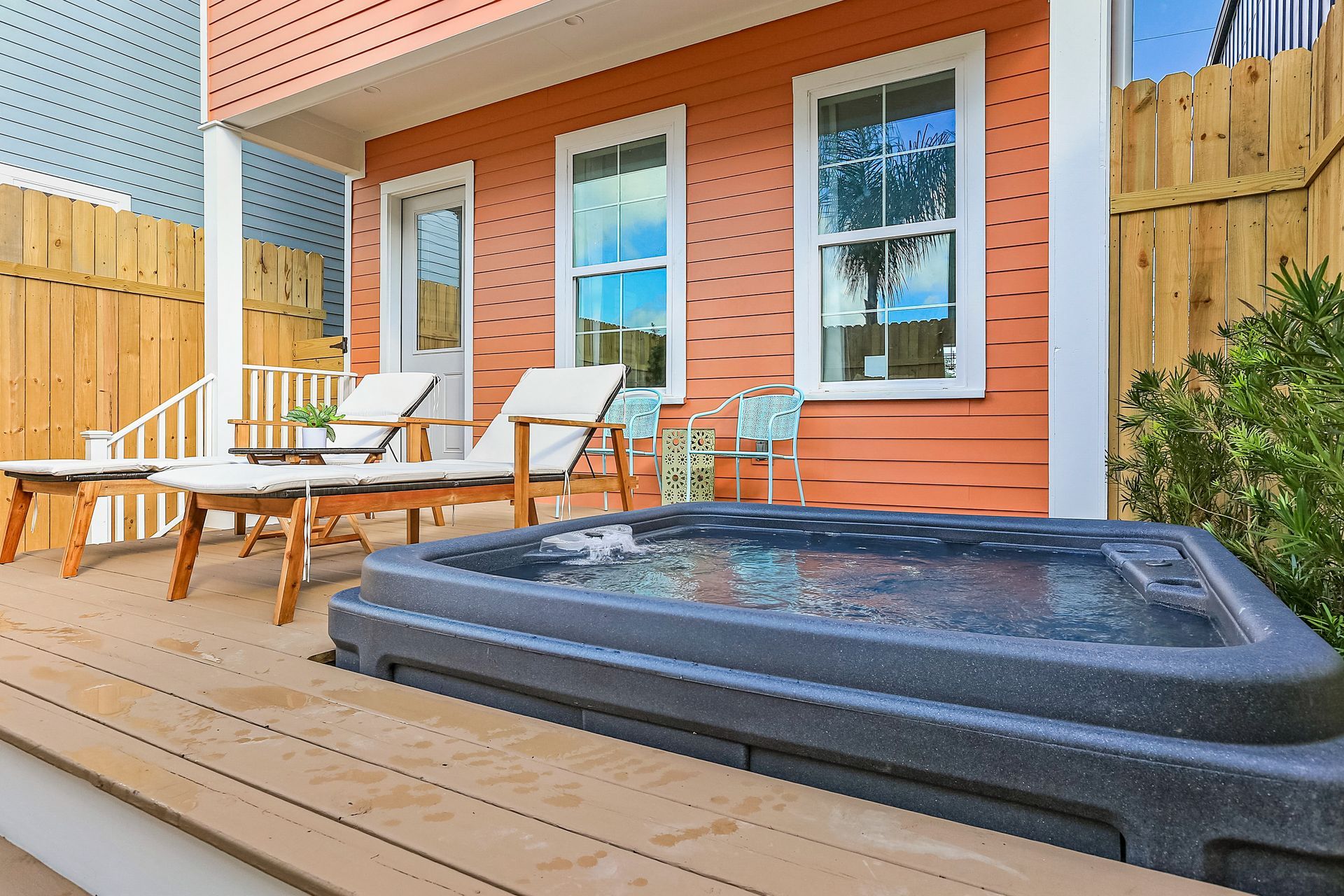 There is a hot tub on the deck of a house.