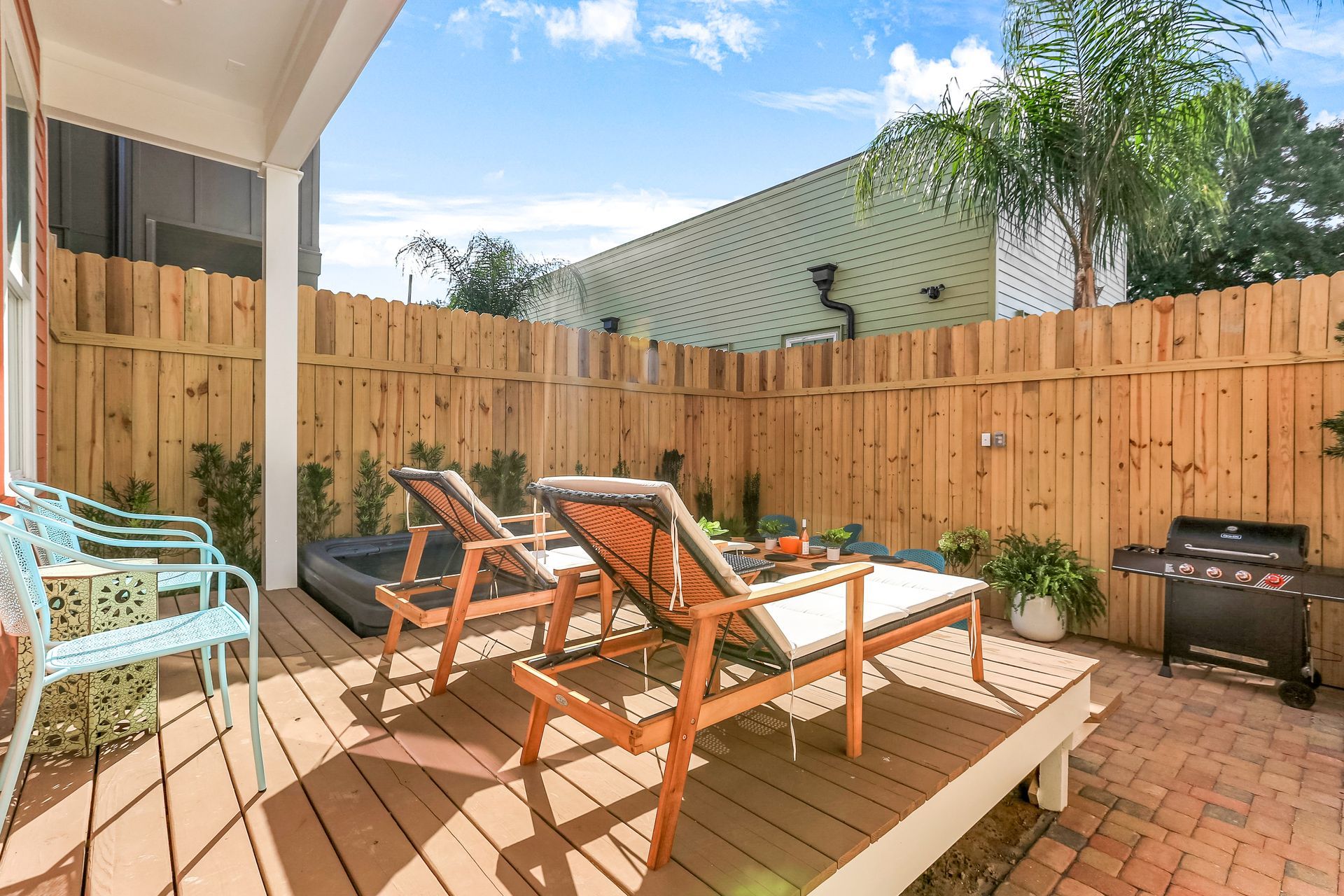 There are two lounge chairs on the deck of a house.