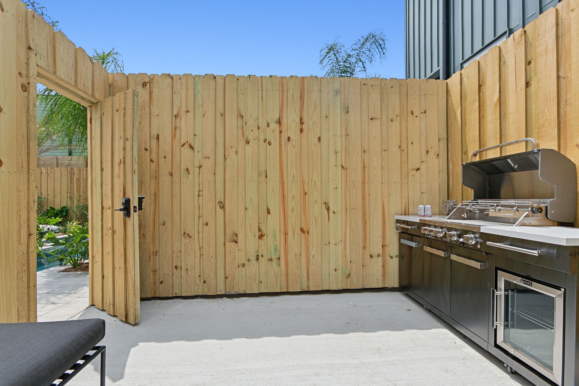 A wooden fence surrounds a kitchen with stainless steel appliances.