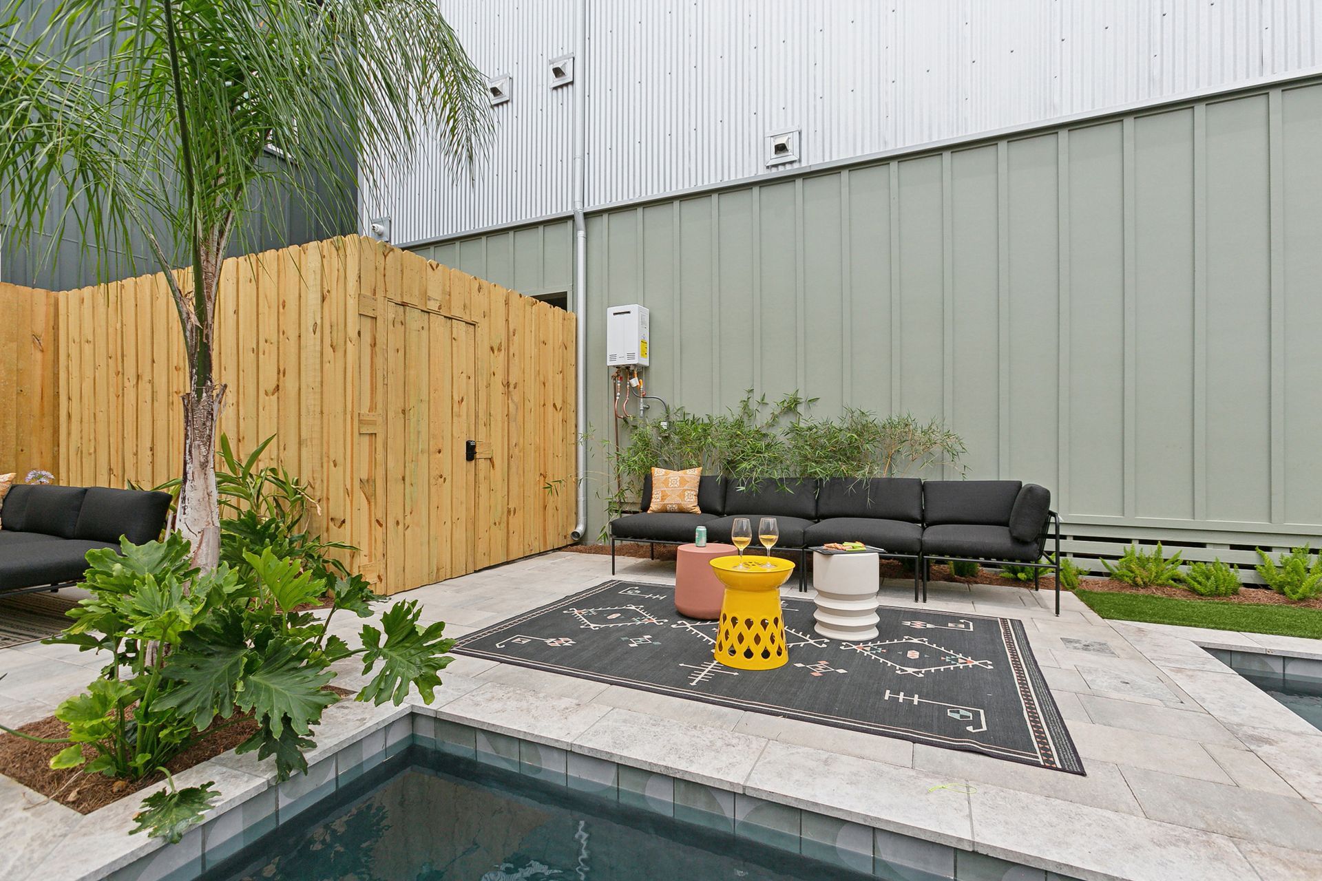 A patio with a swimming pool and a couch and tables