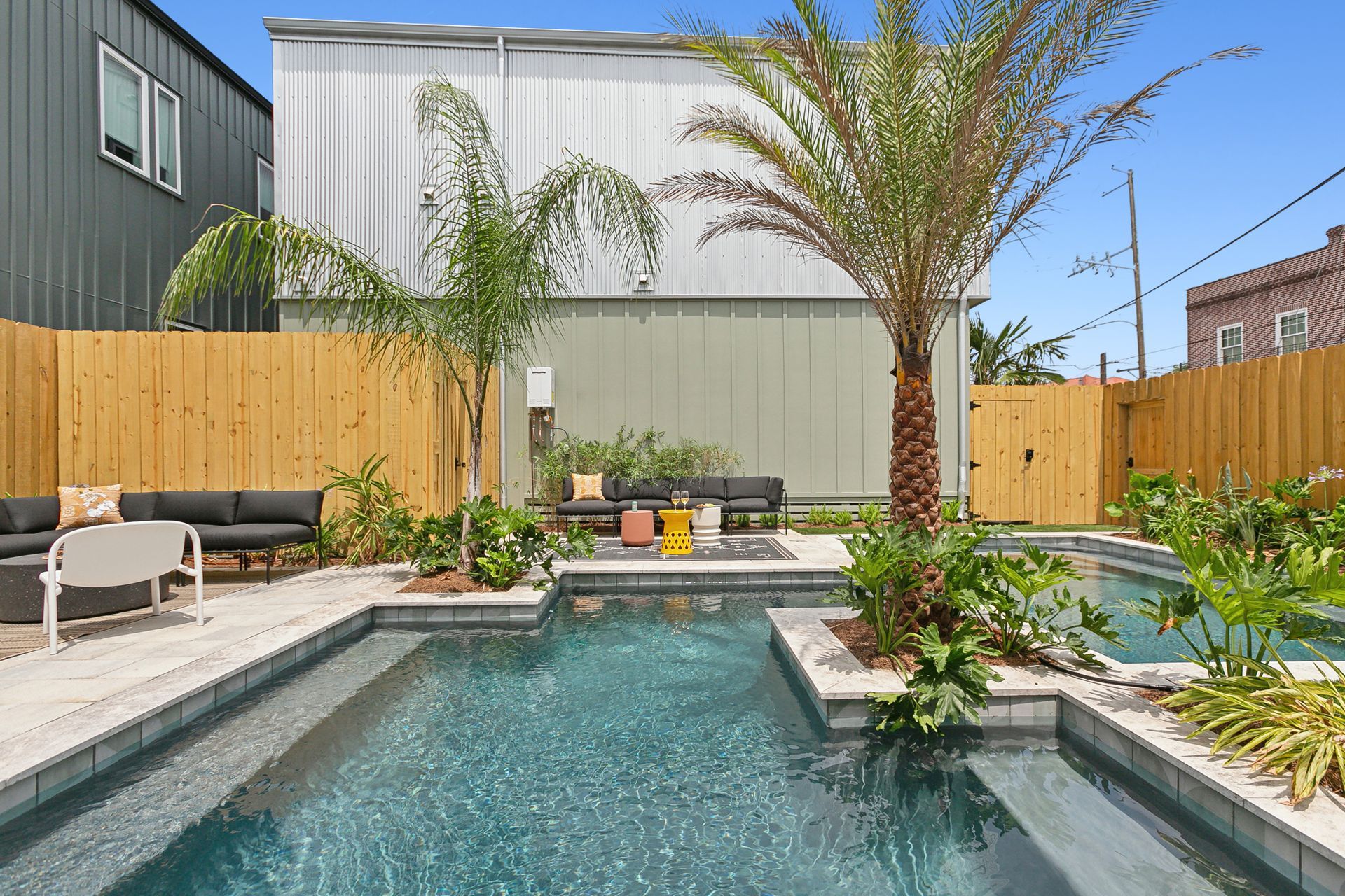 There is a large swimming pool in the backyard of a house.