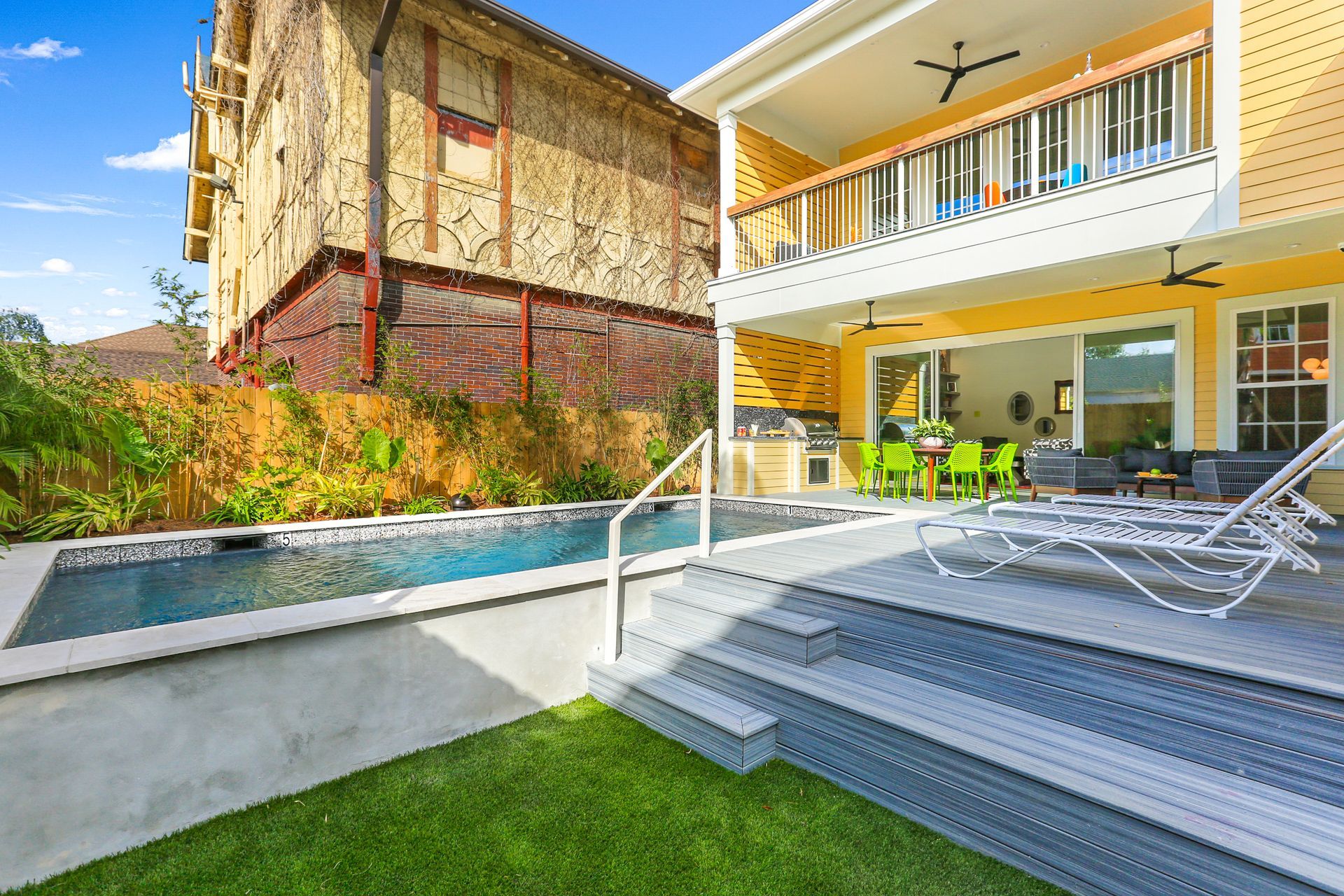 There is a large swimming pool in the backyard of a house.