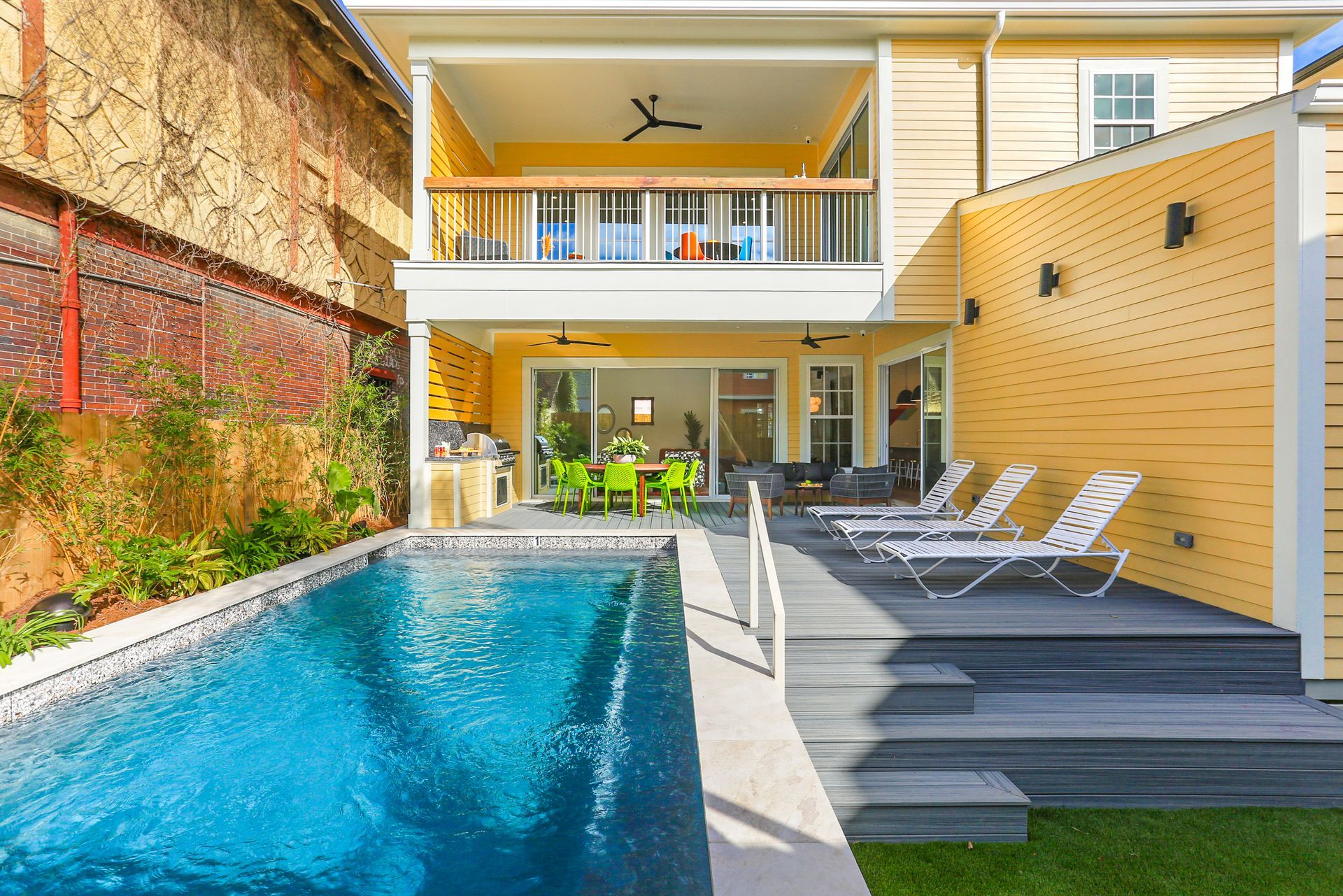 There is a large swimming pool in the backyard of a house.