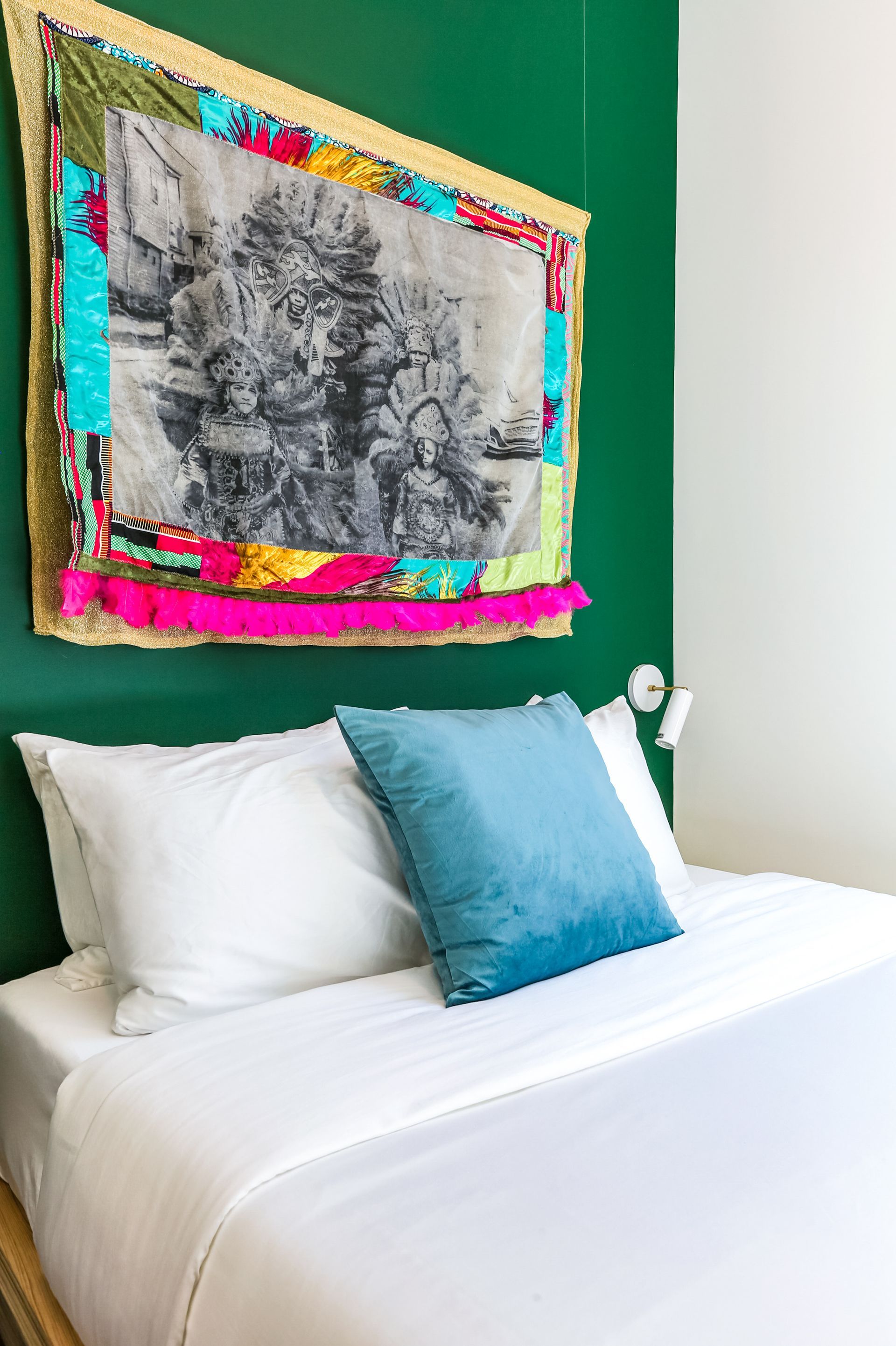 There is a painting on the wall above the bed.