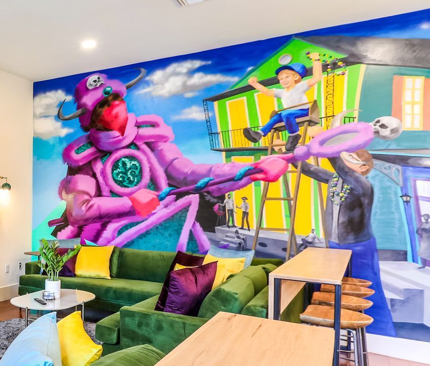 A living room with a large mural on the wall