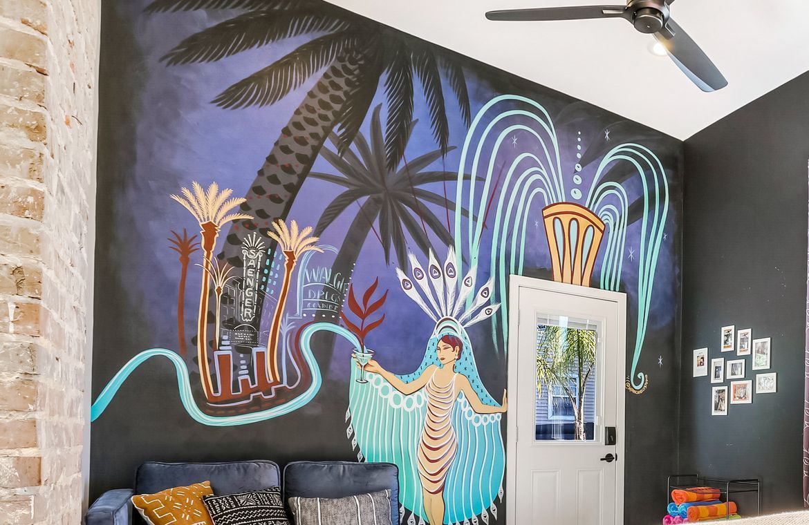 A living room with a couch and a painting on the wall.