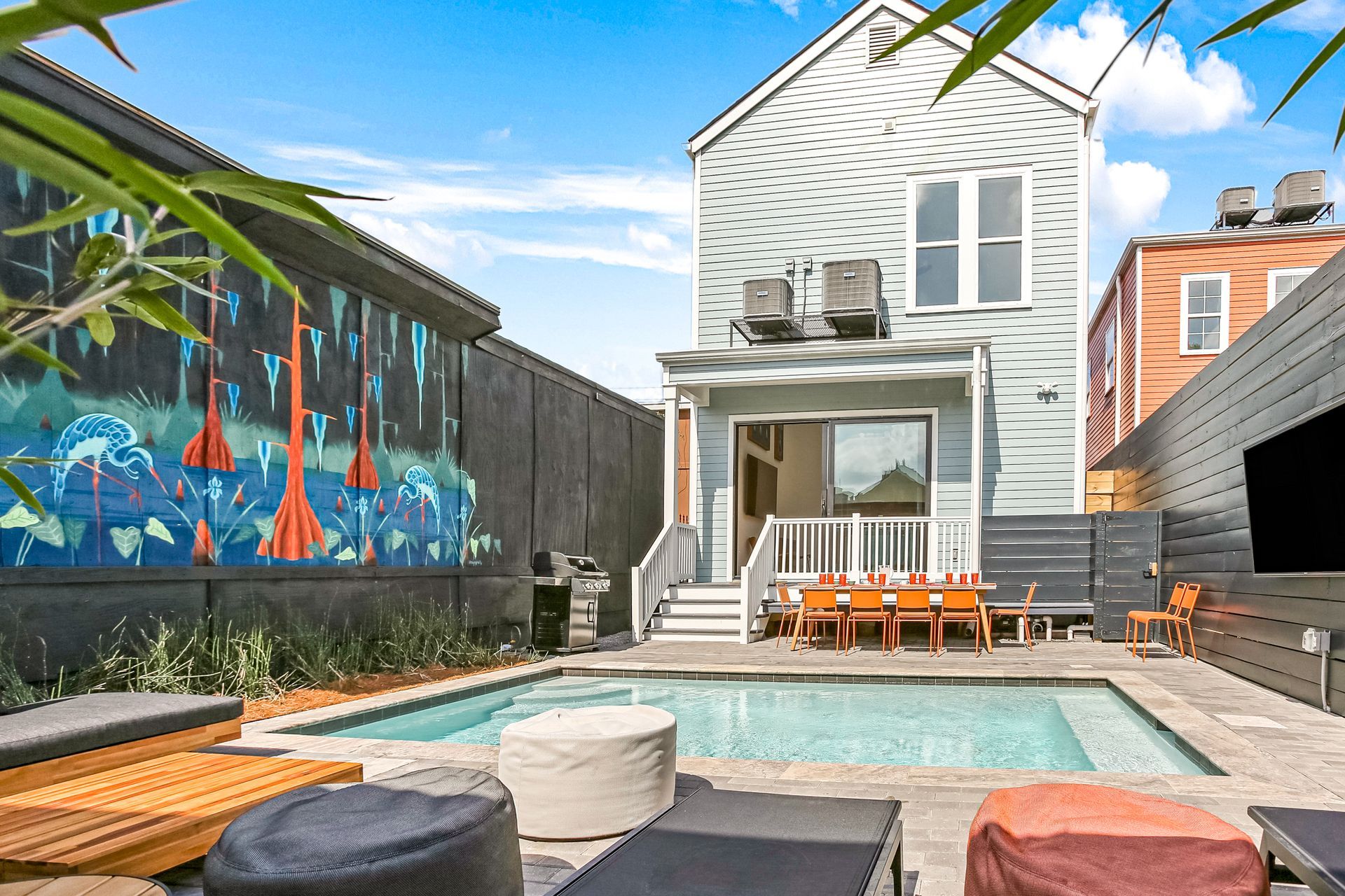 There is a large swimming pool in the backyard of a house.