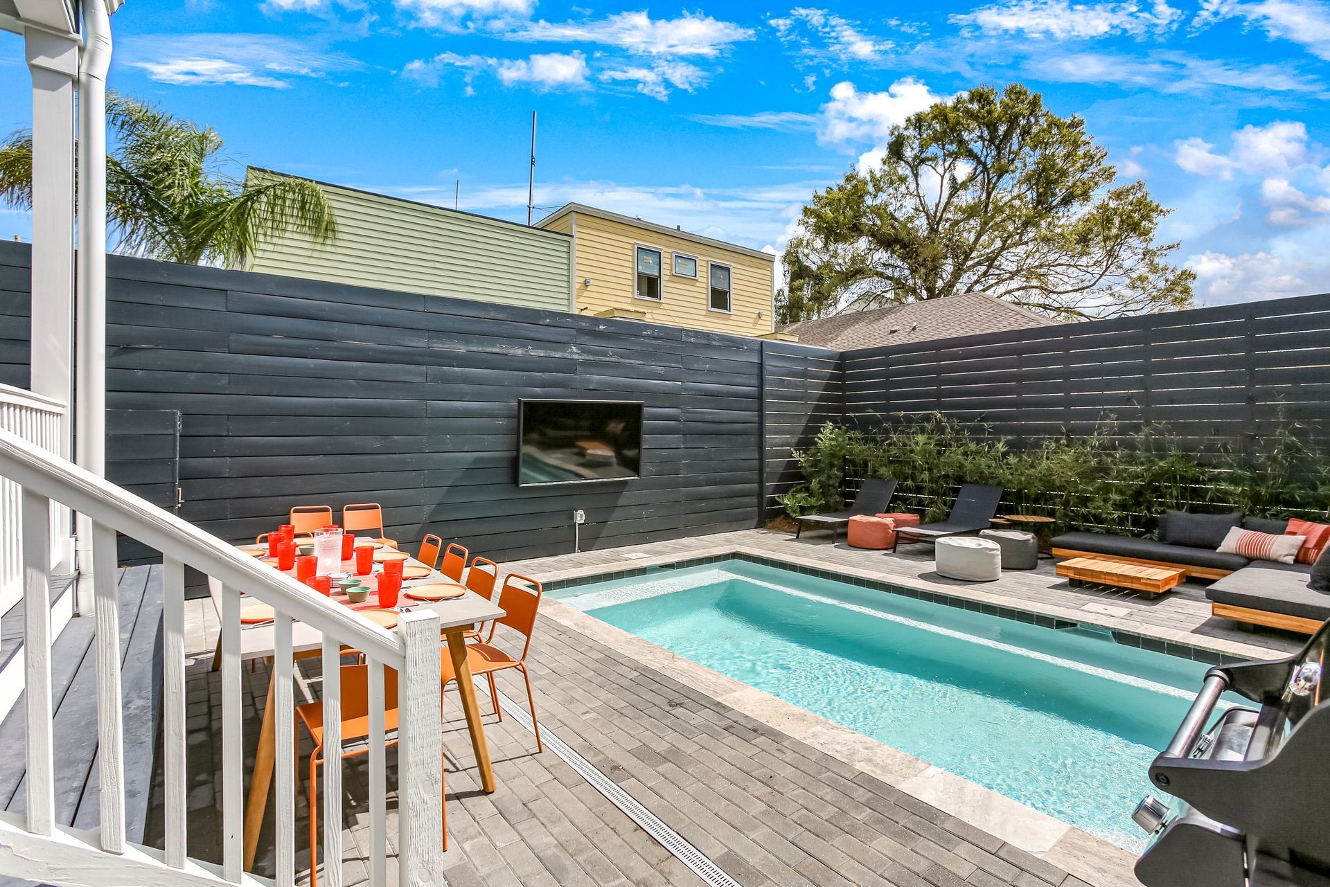 There is a large swimming pool in the backyard of a house.