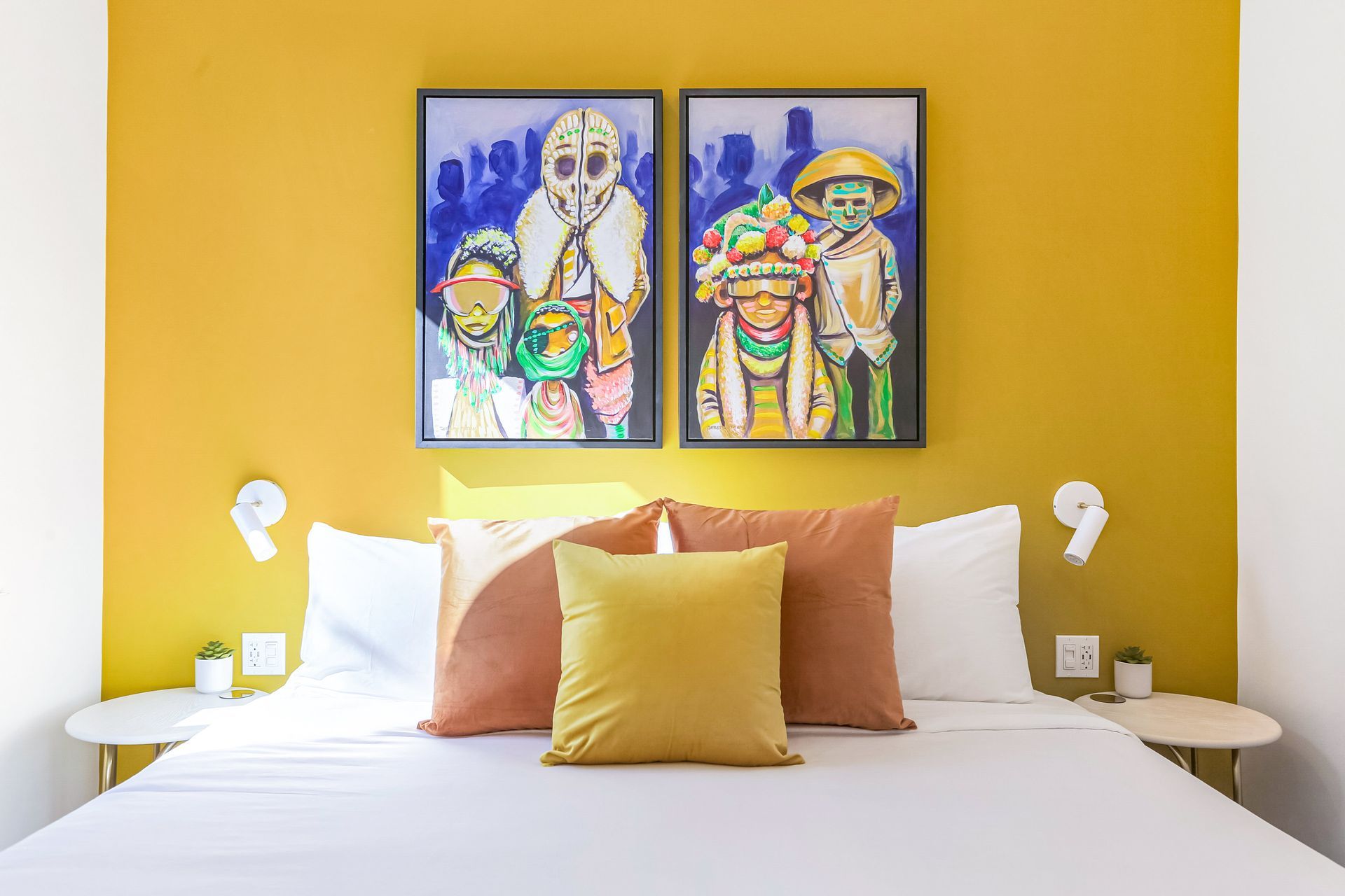 There are two paintings on the wall above the bed.