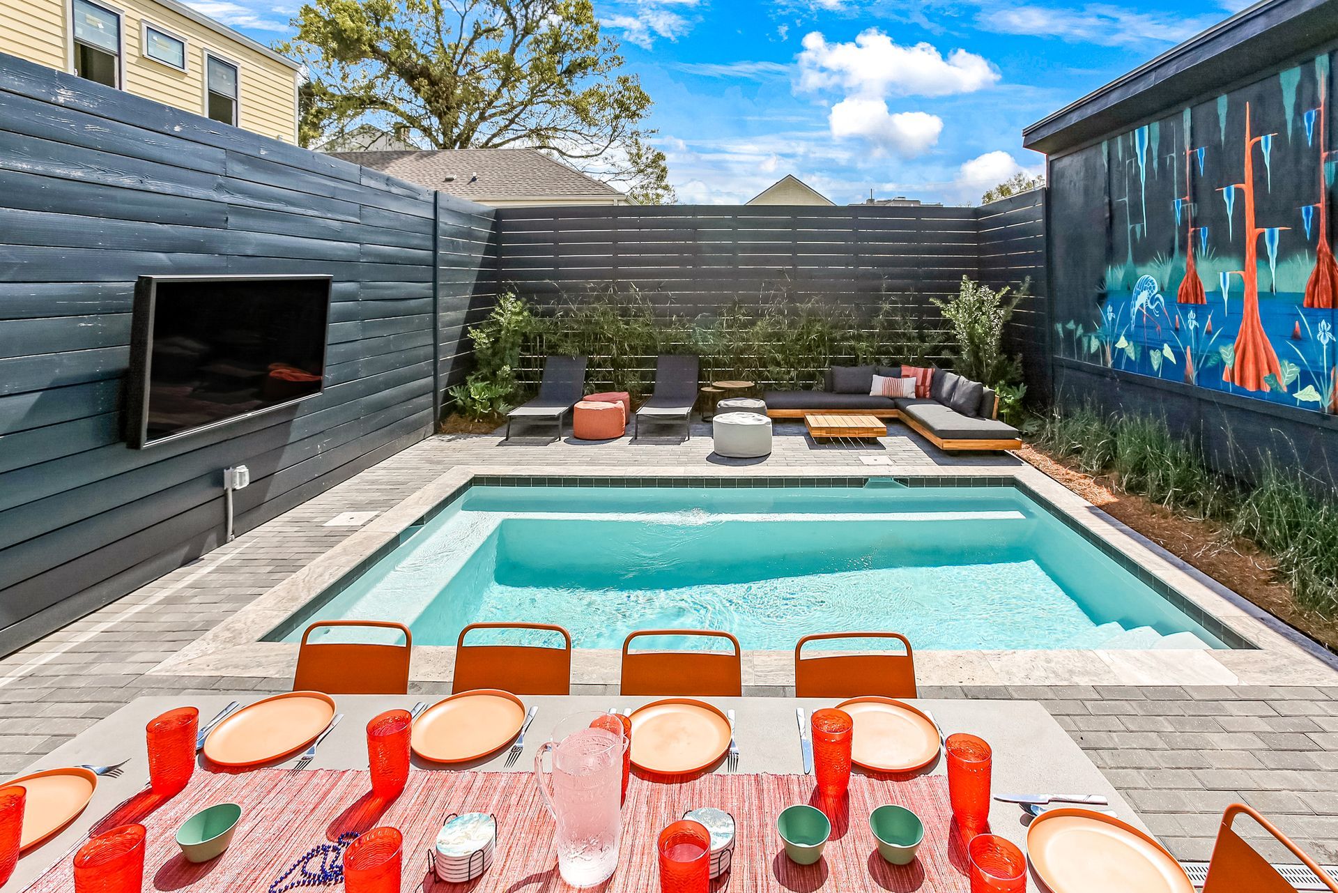 A large swimming pool with a table and chairs in front of it.