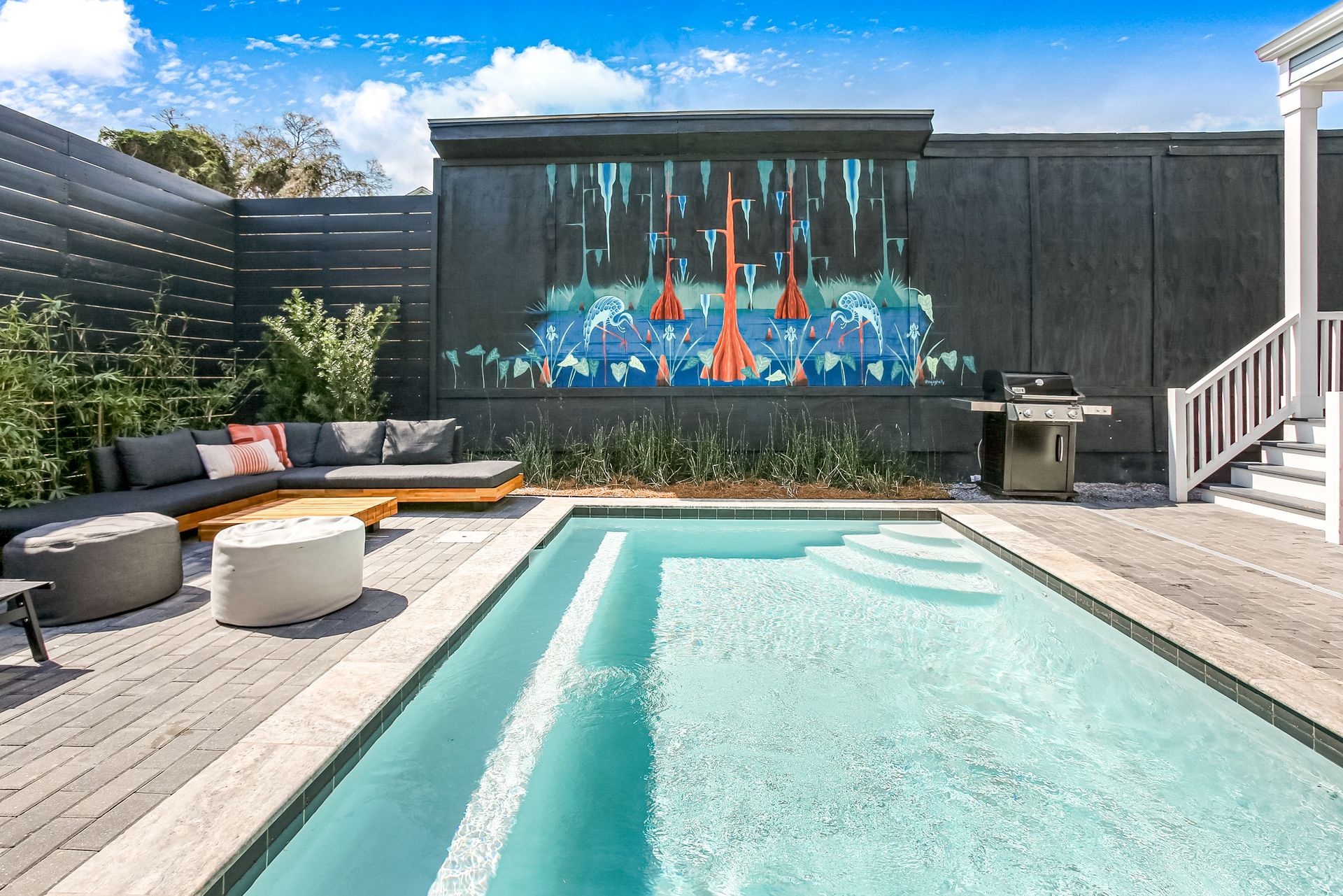 There is a large swimming pool in the backyard of a house.