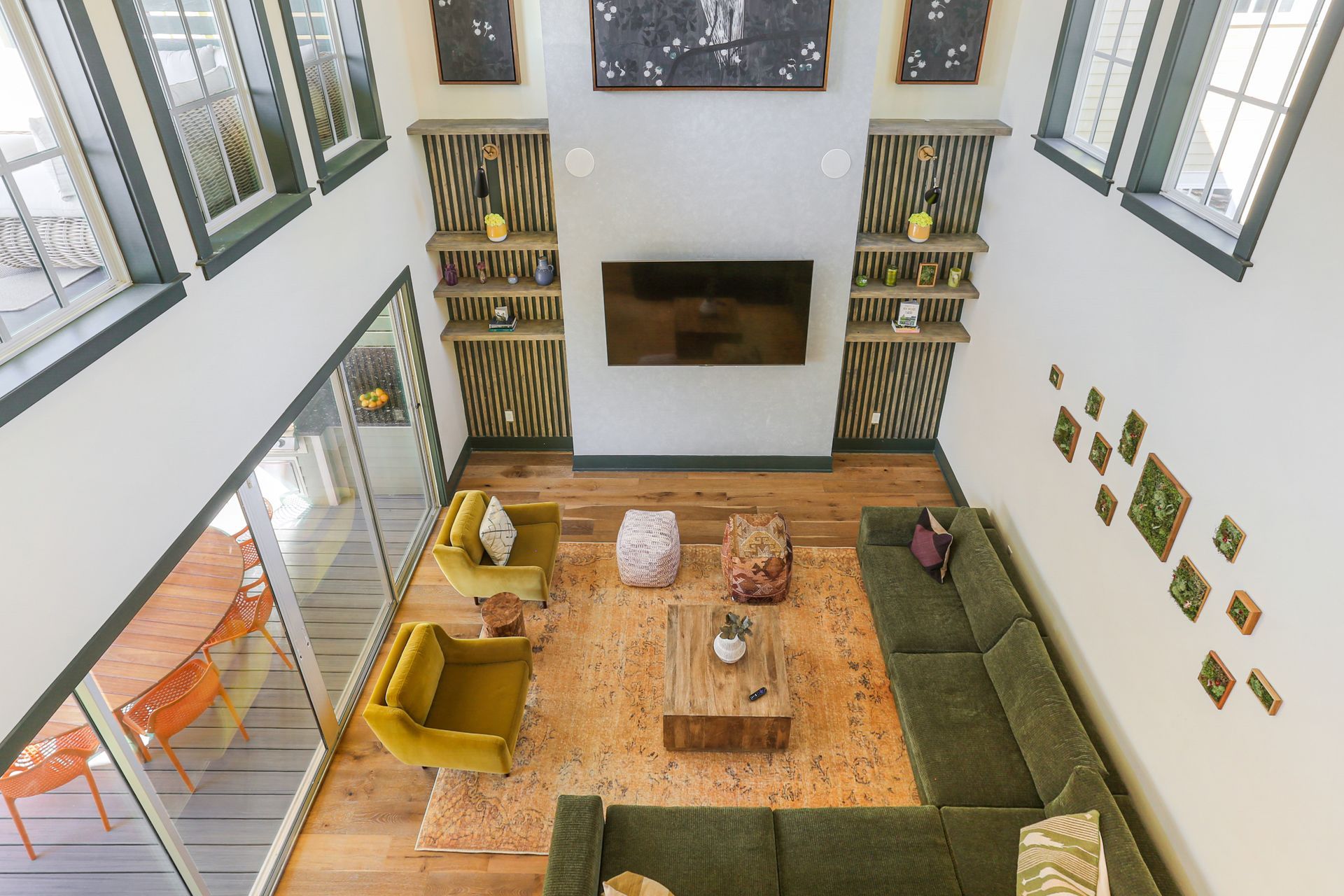 An aerial view of a living room with a green couch and yellow chairs.