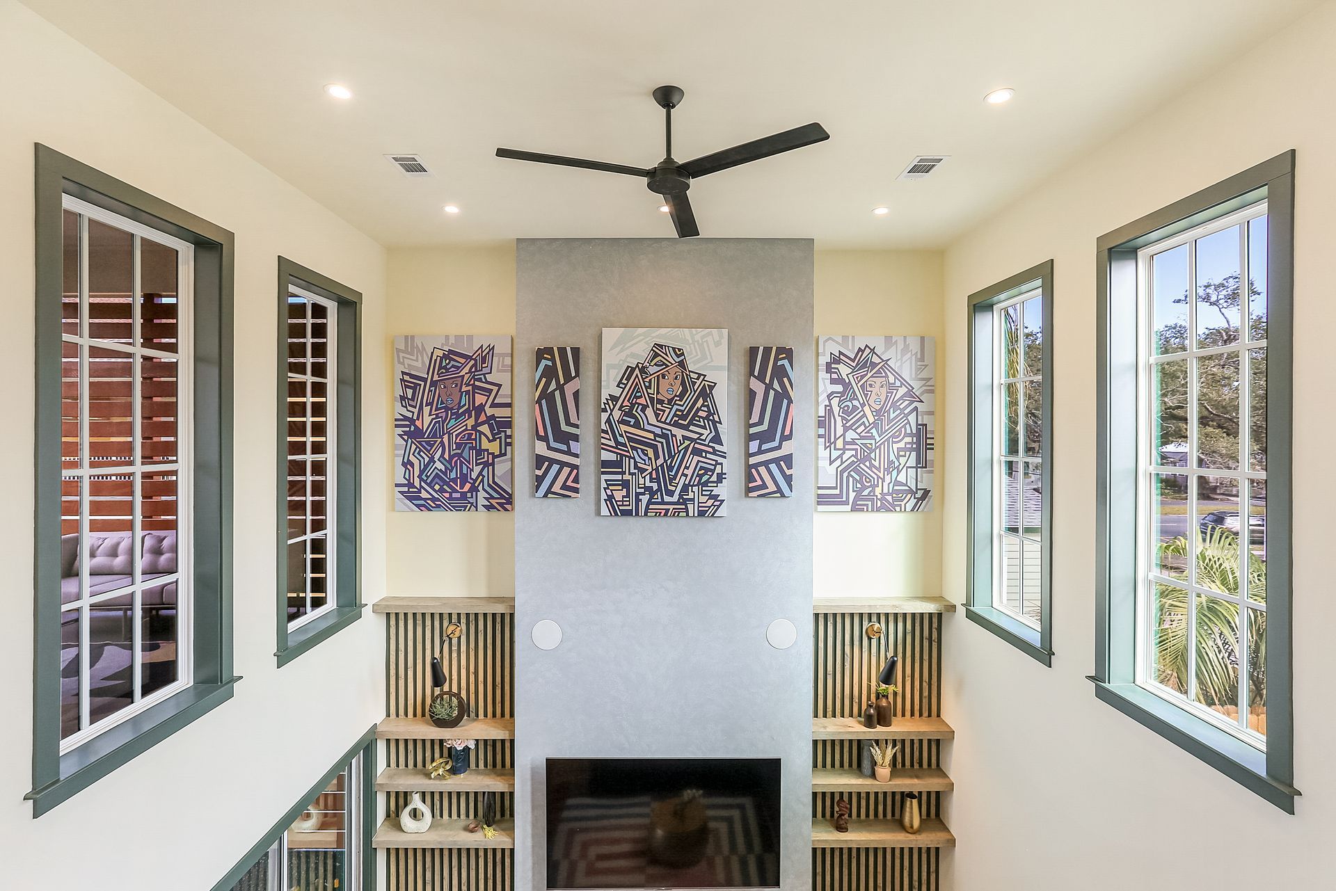 A living room with a fireplace and a ceiling fan