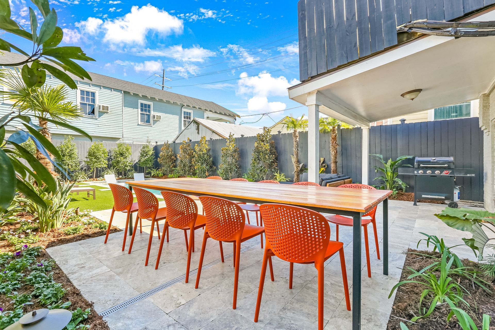 A patio with a table and chairs in front of a house.