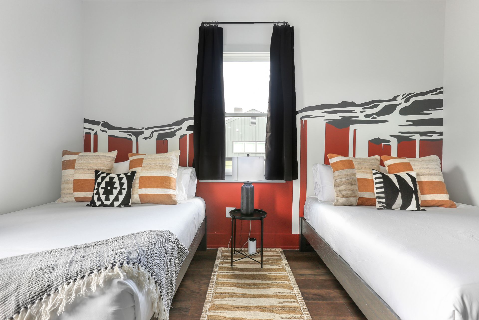 A bedroom with two beds and a window.