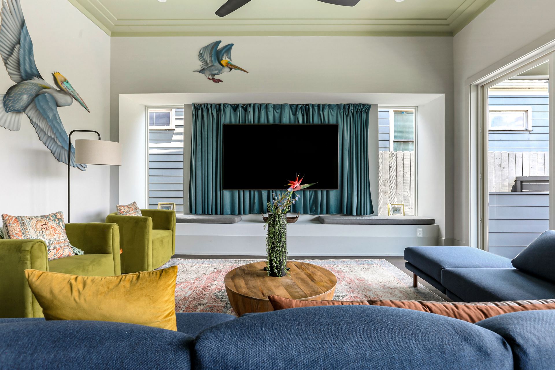 A living room with a couch , chairs , and a flat screen tv.