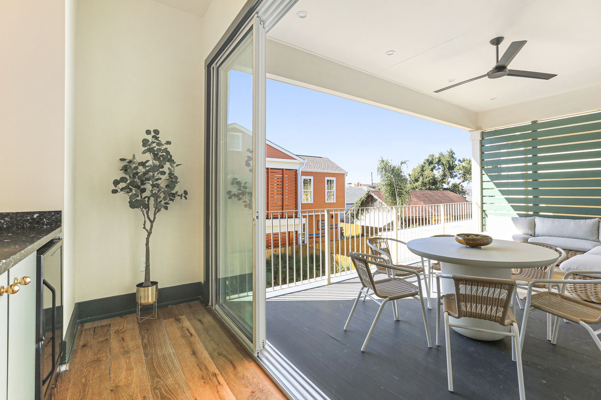 A balcony with a table and chairs and a ceiling fan.