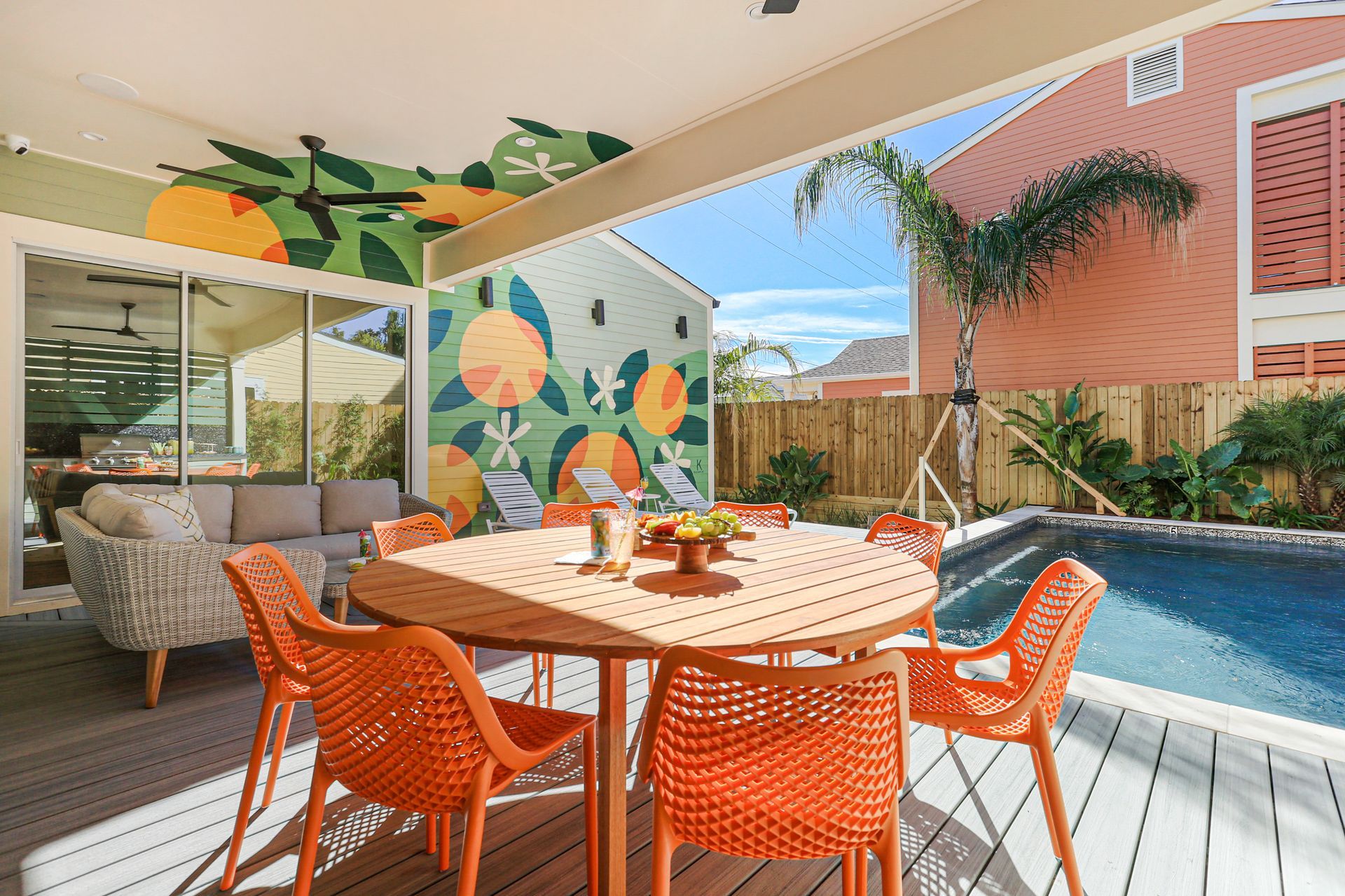 A patio with a table and chairs next to a pool.