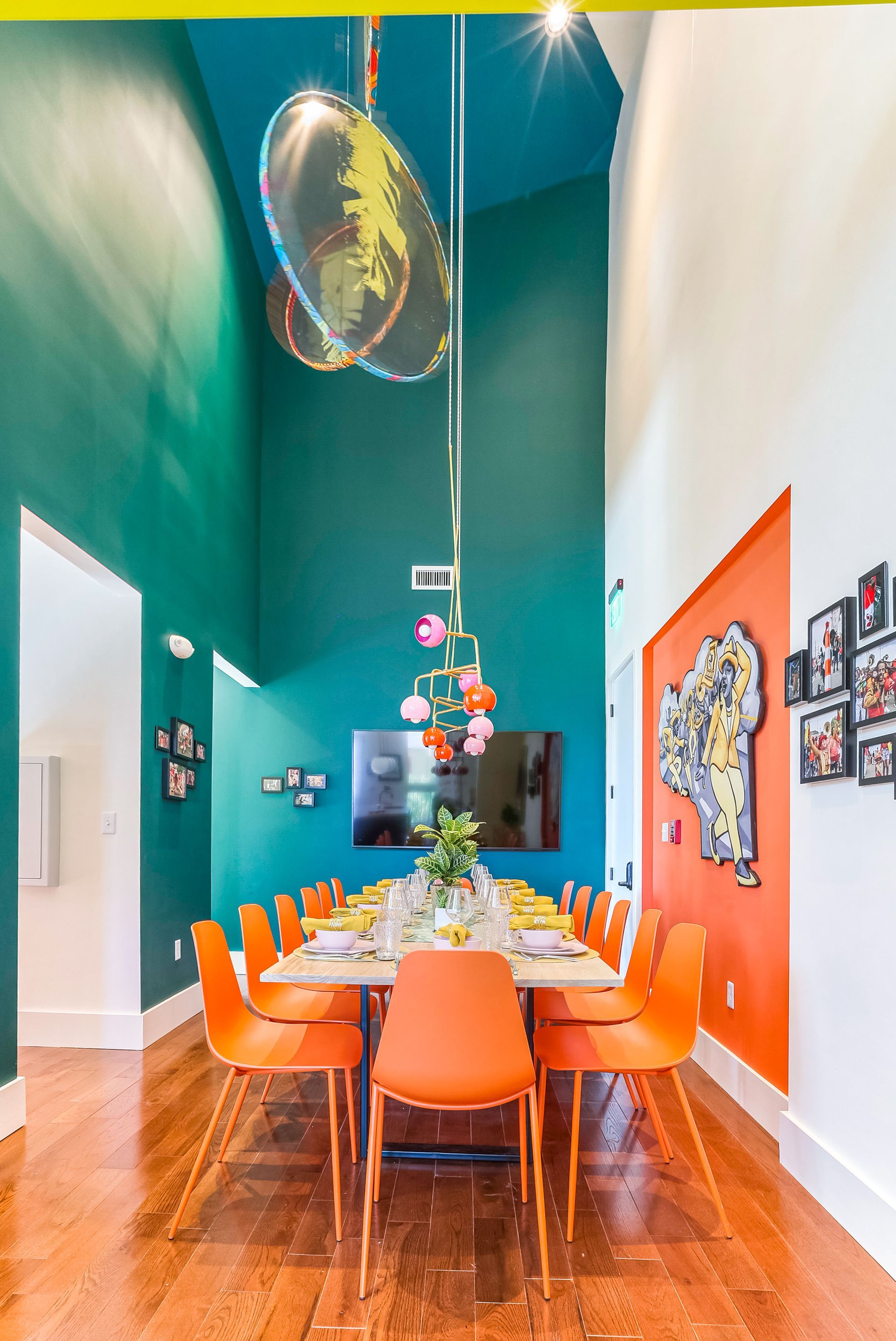 A dining room with a long table and orange chairs