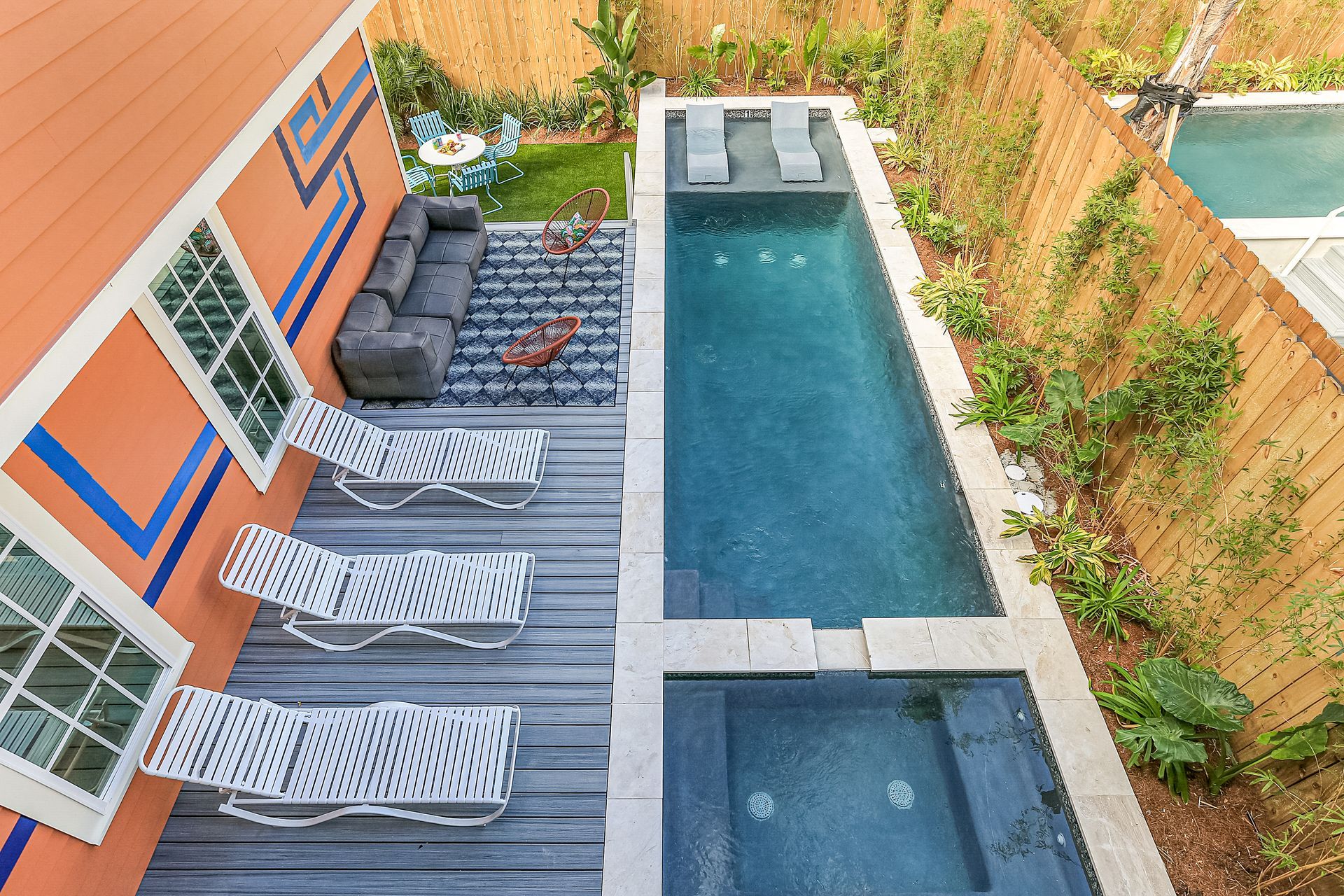 An aerial view of a backyard with a swimming pool and lounge chairs