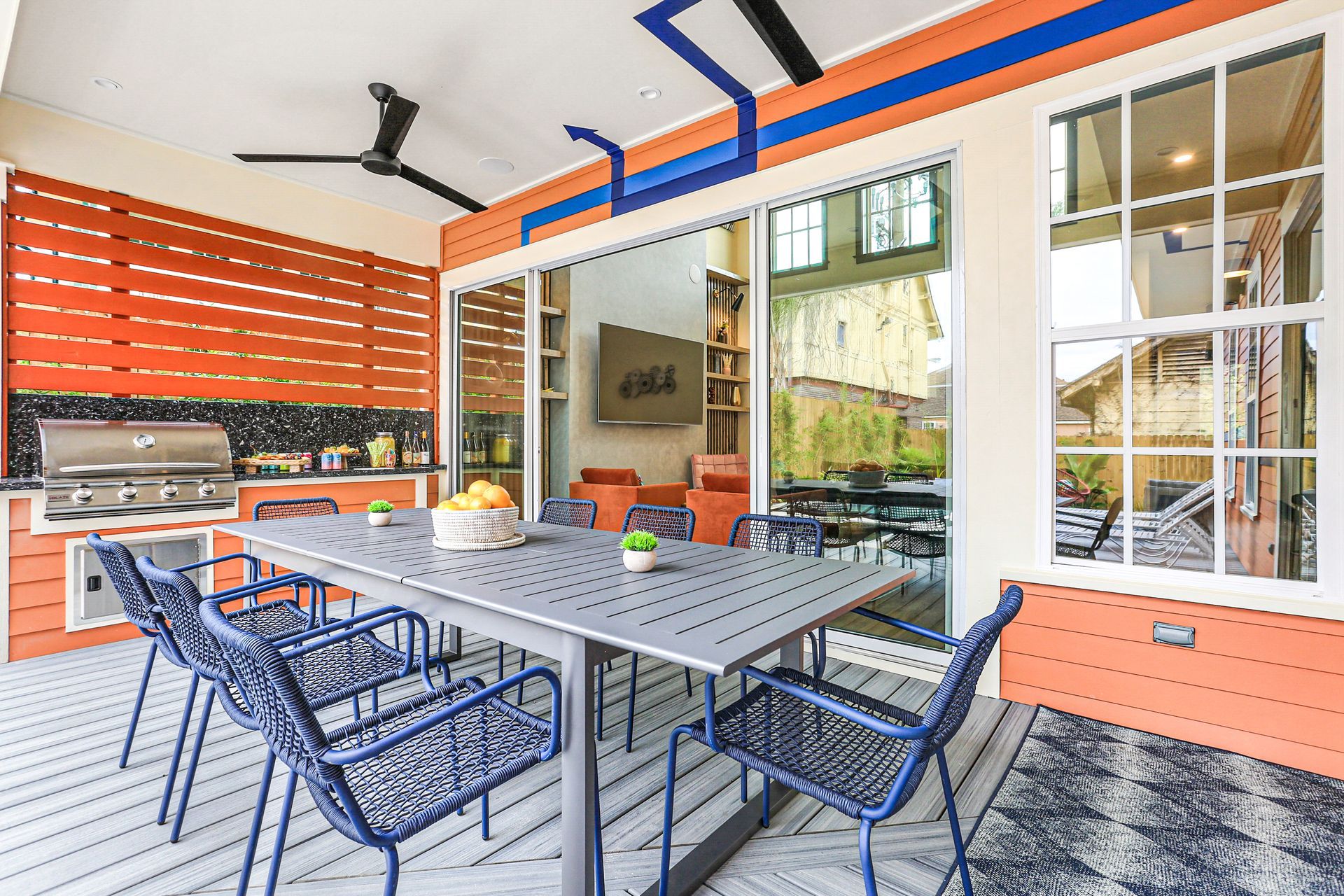 A patio with a table and chairs and a ceiling fan.
