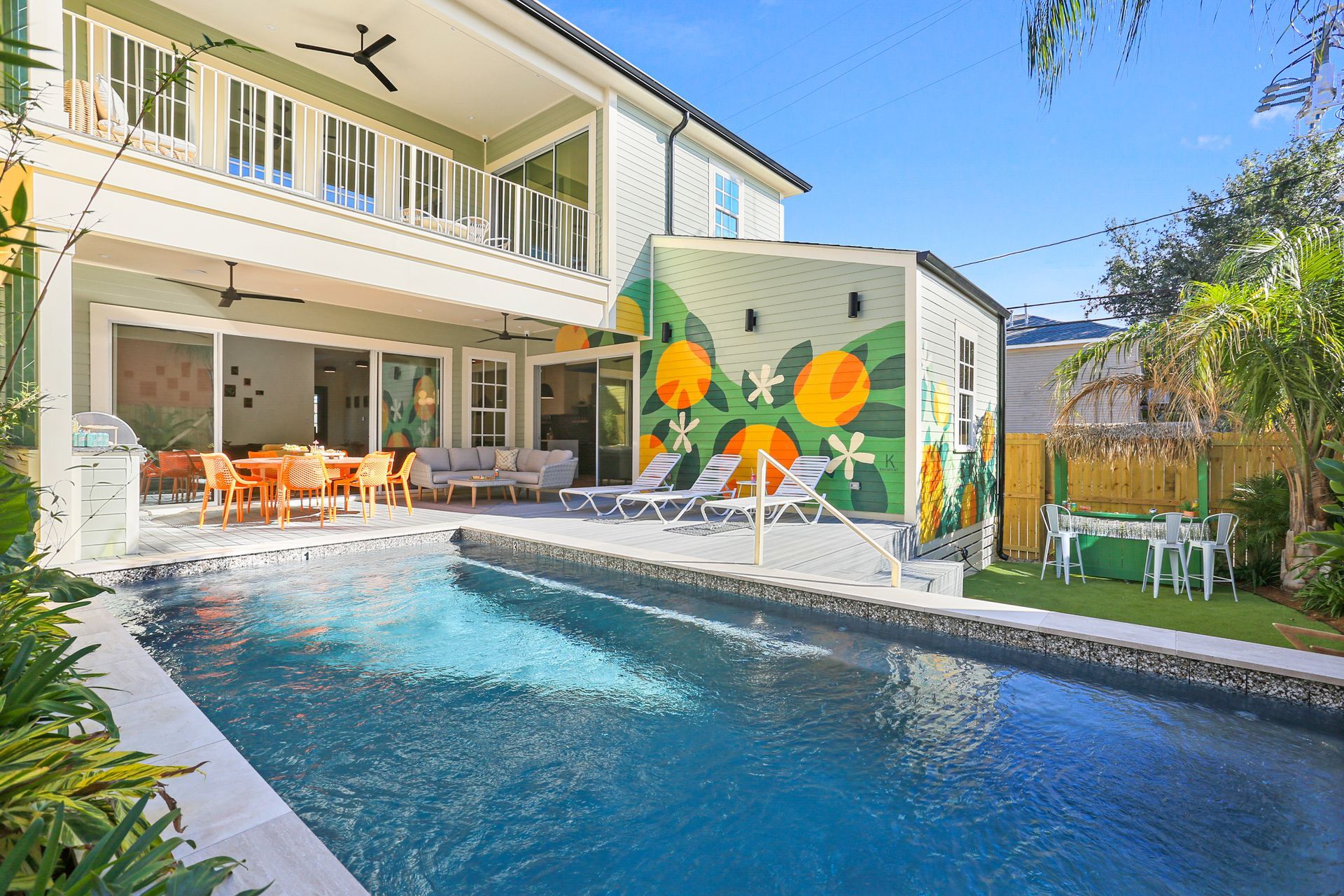 There is a large swimming pool in the backyard of a house.