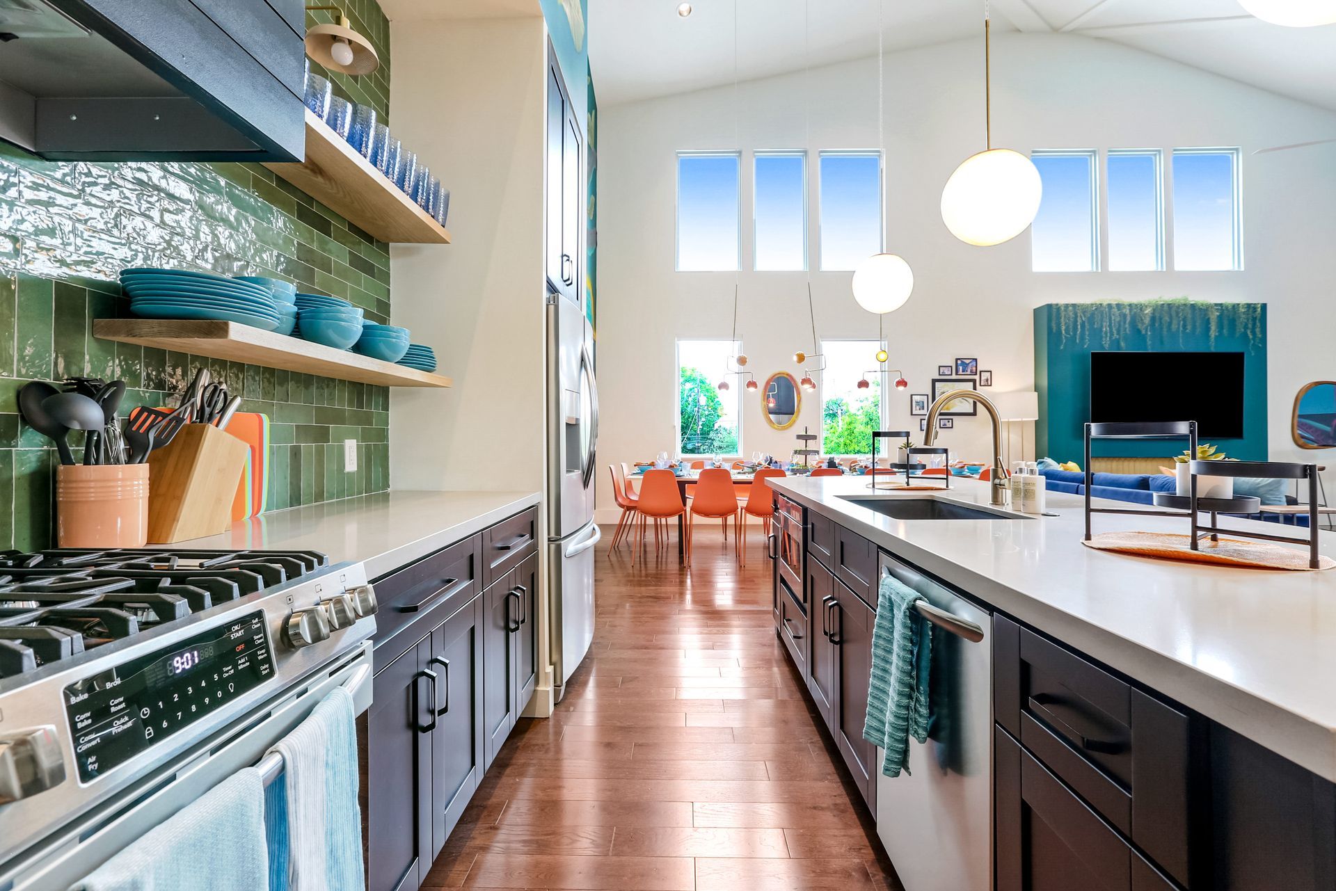 A kitchen with a stove , sink , refrigerator , and a large island.