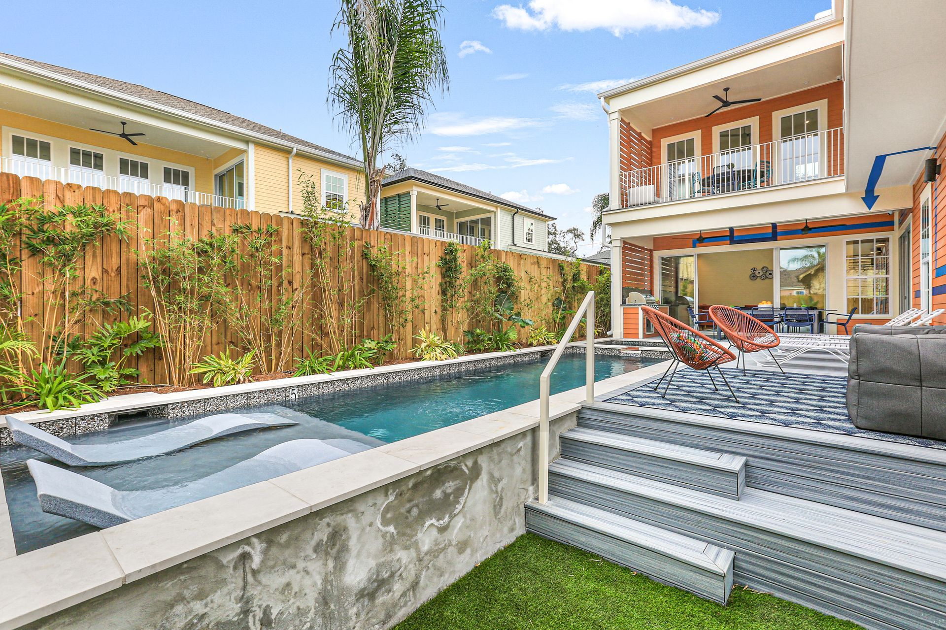 There is a large swimming pool in the backyard of a house.