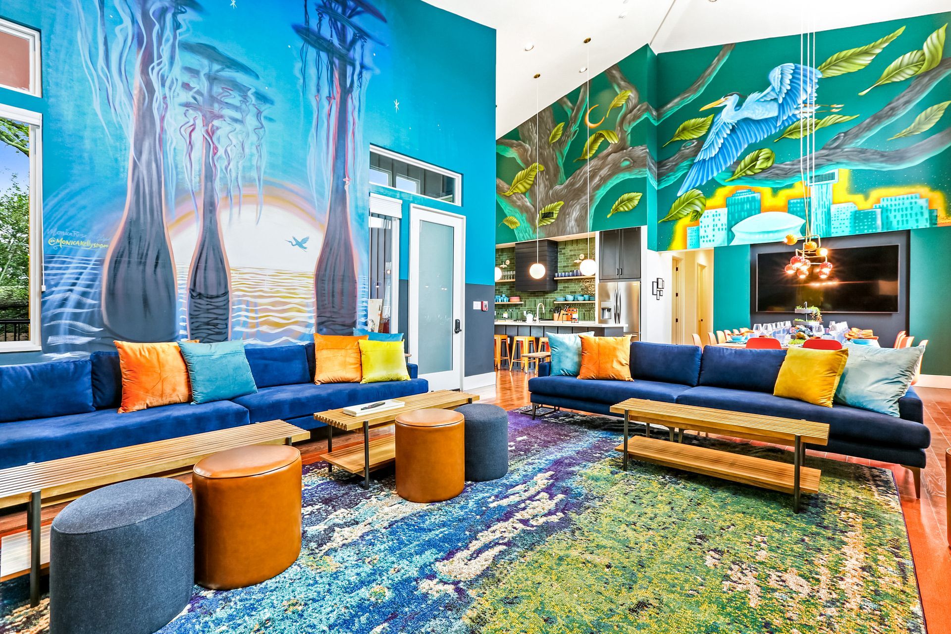 A living room with colorful furniture and a mural on the wall.