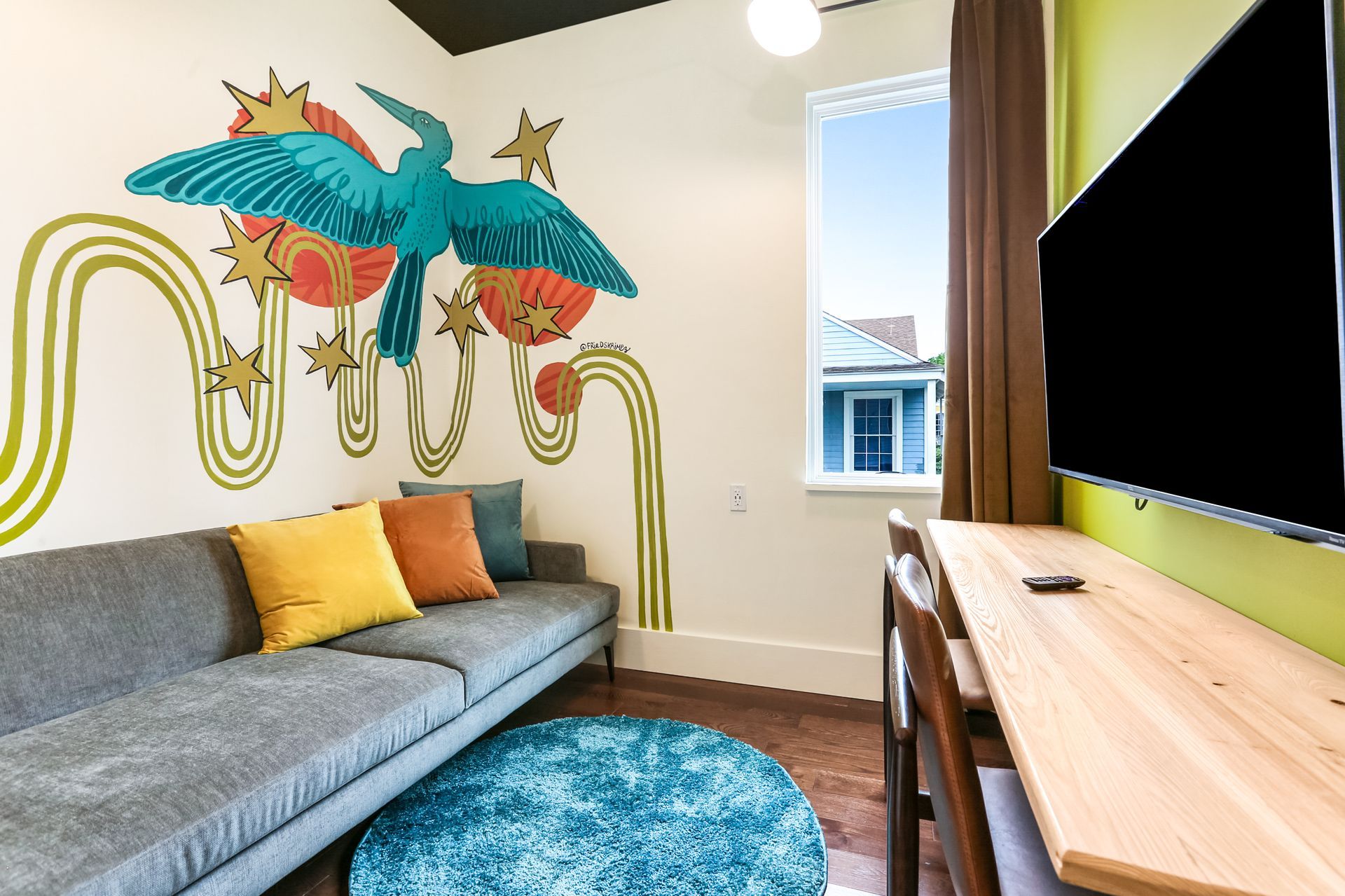 A living room with a couch a desk and a television