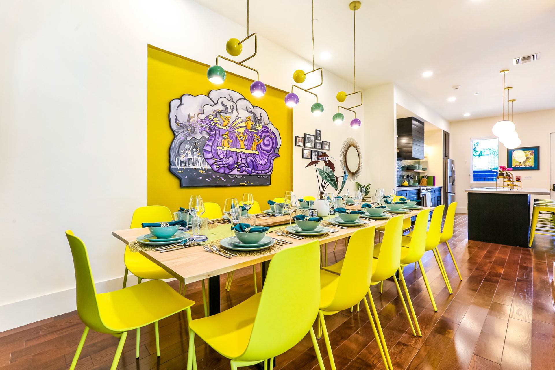 A dining room with a long table and yellow chairs.