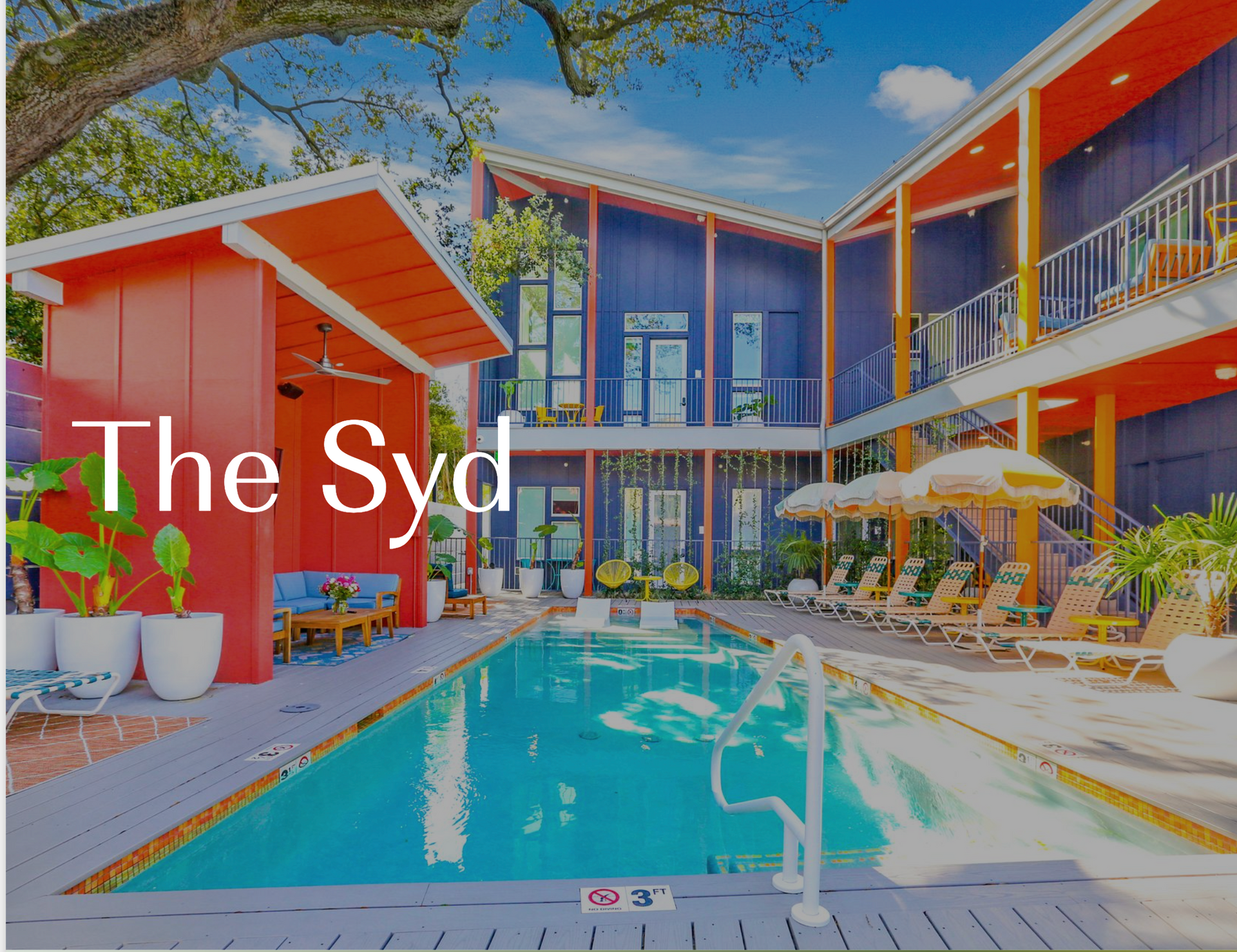 A large swimming pool in front of a building that says the syd