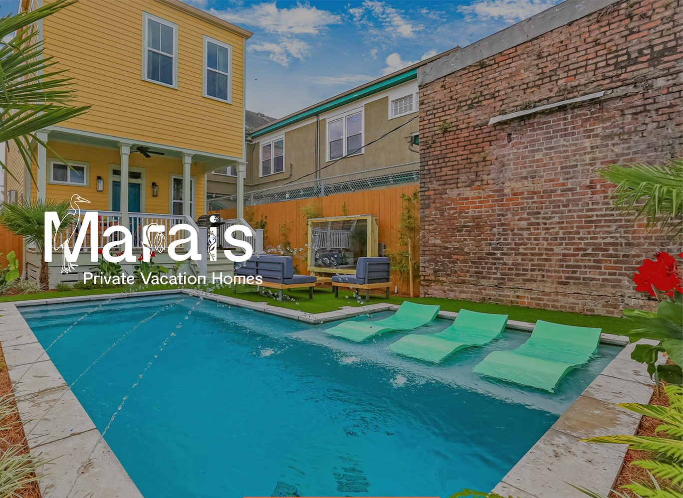 A large swimming pool is in the backyard of a house.