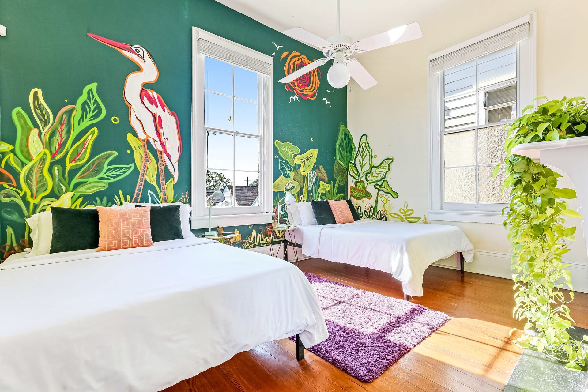 A bedroom with two beds and a painting on the wall.