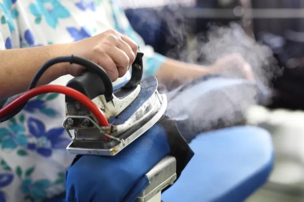 Primer plano de camisas con cuello en varios colores y rayas colgadas en perchas negras.