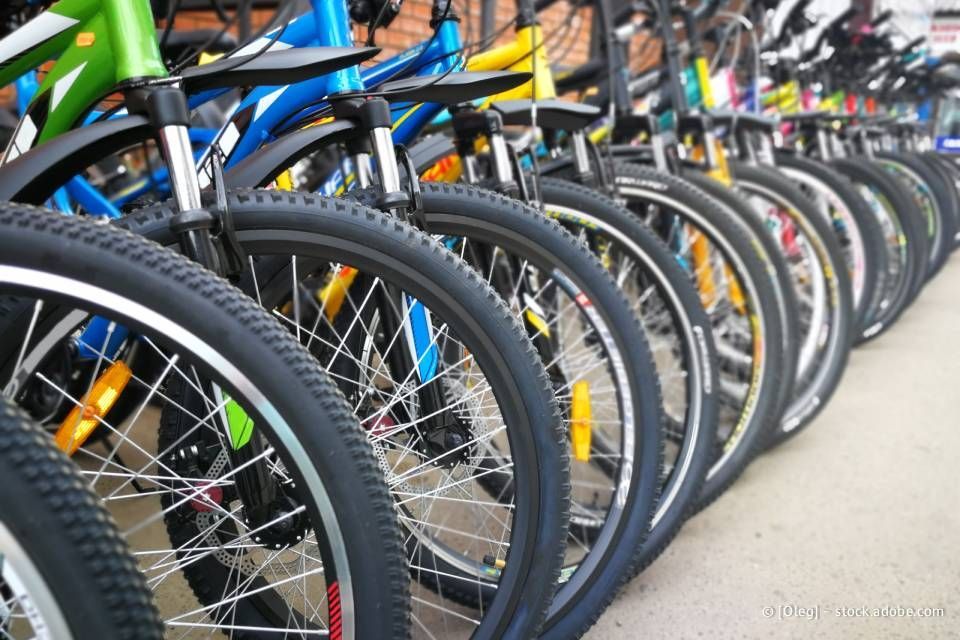 Eine Reihe von Fahrrädern mit Rahmen und Reifen in verschiedenen Farben ist ausgestellt.