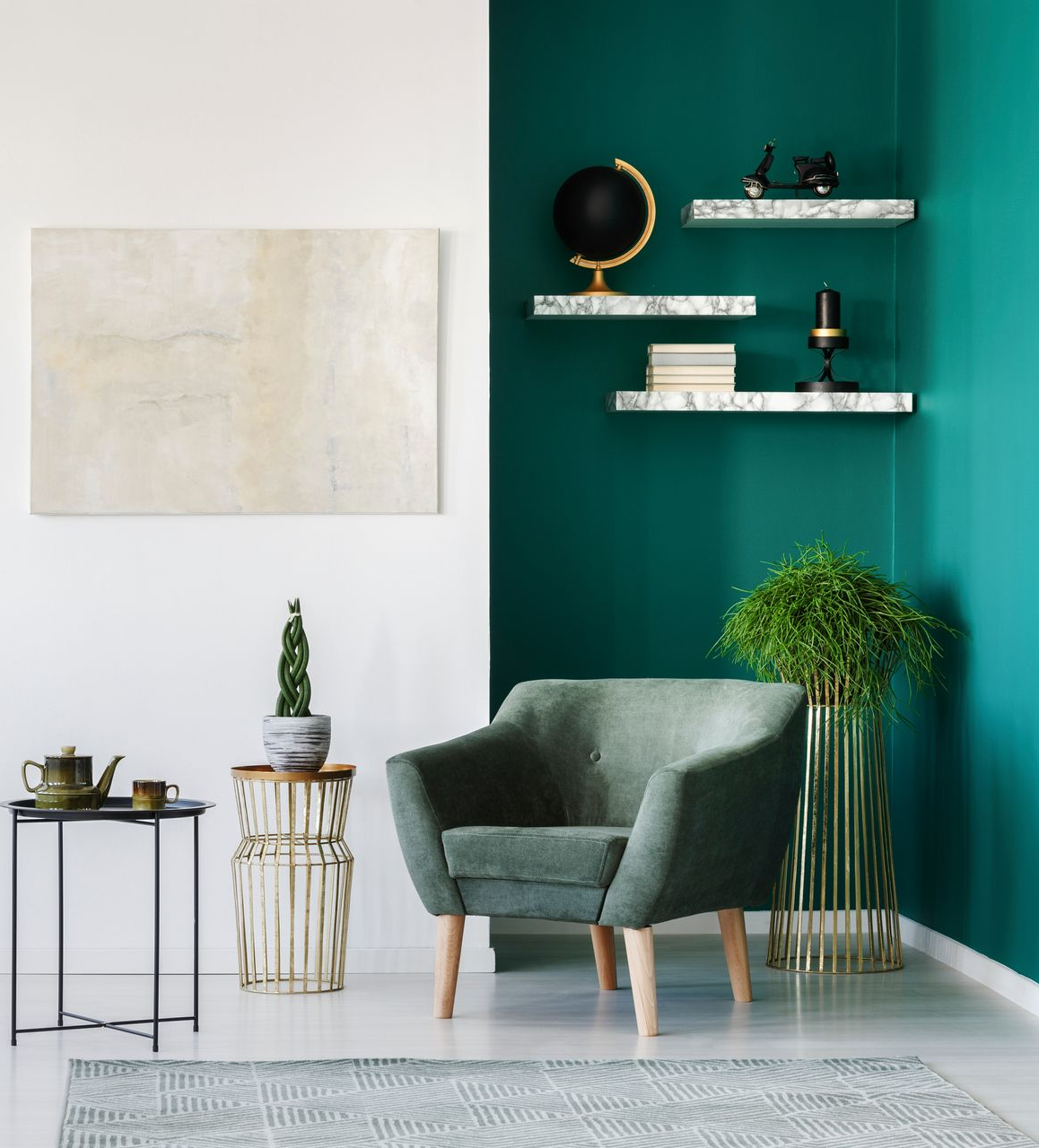 Coin salon avec murs verts, fauteuil, étagères et œuvres d'art.
