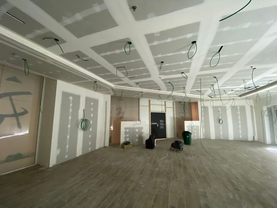 Intérieur d'une pièce en construction, avec cloisons sèches installées sur les murs et le plafond.