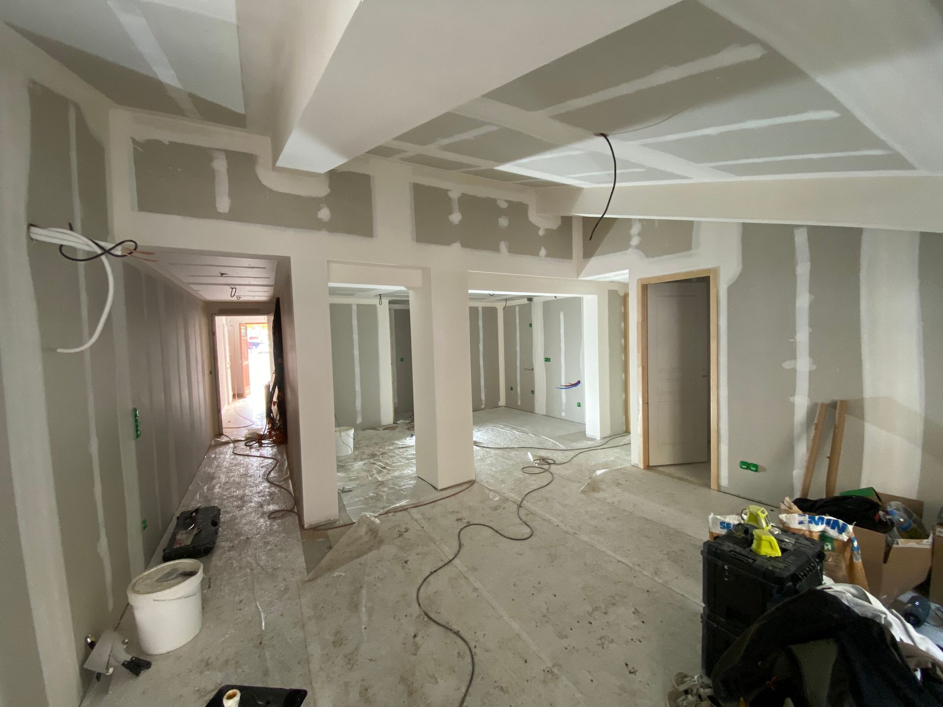 Pièce intérieure en construction, avec cloisons sèches sur les murs et le plafond, fils exposés.