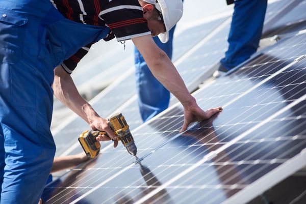 Professionnels installant des panneaux solaires