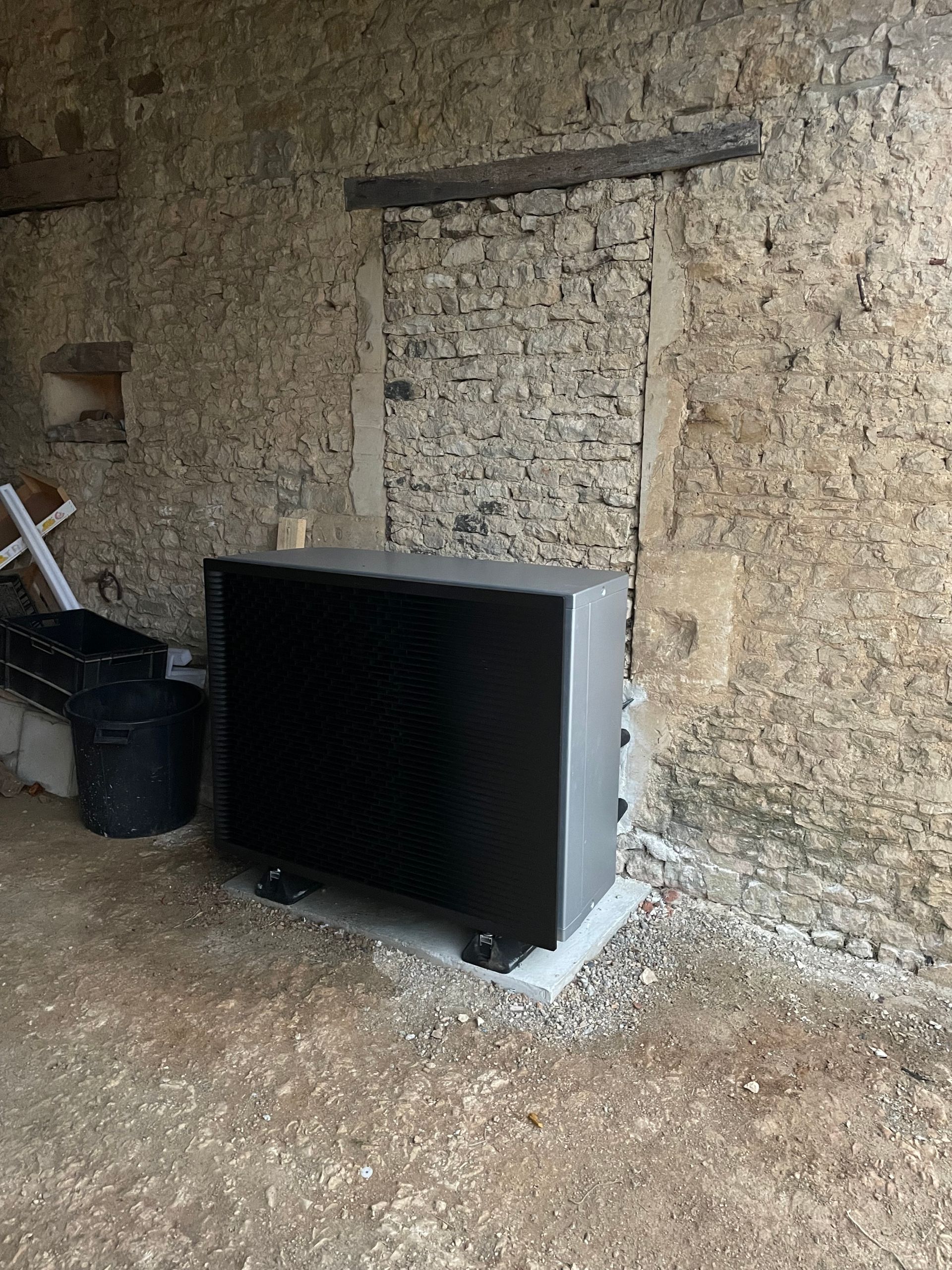 Pompe à chaleur à l'extérieur d'une maison avec un mur ancien