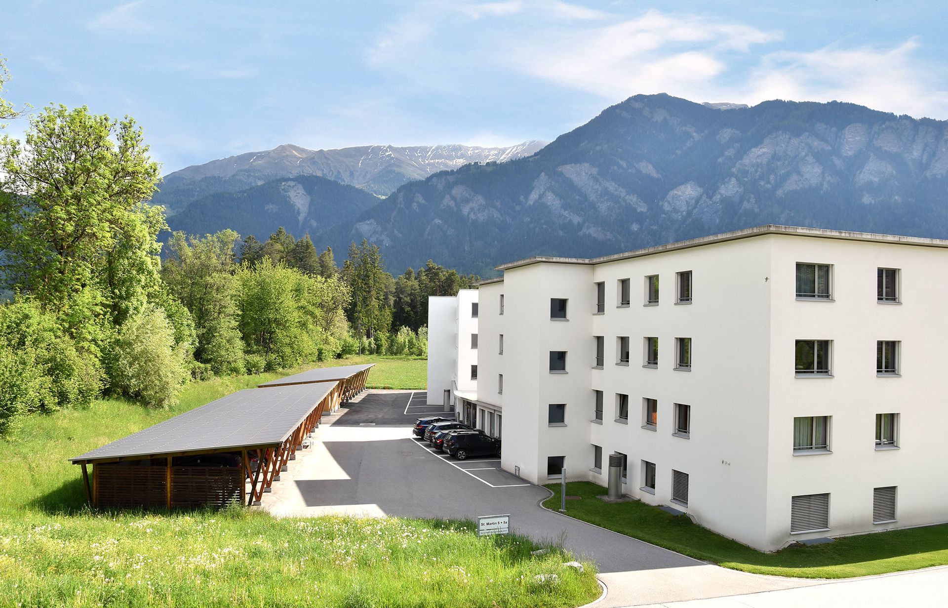 Pflegerin hält die Hand von alter Frau im Rollstuhl, Genossenschaft Alterswohnungen St. Martin Cazis